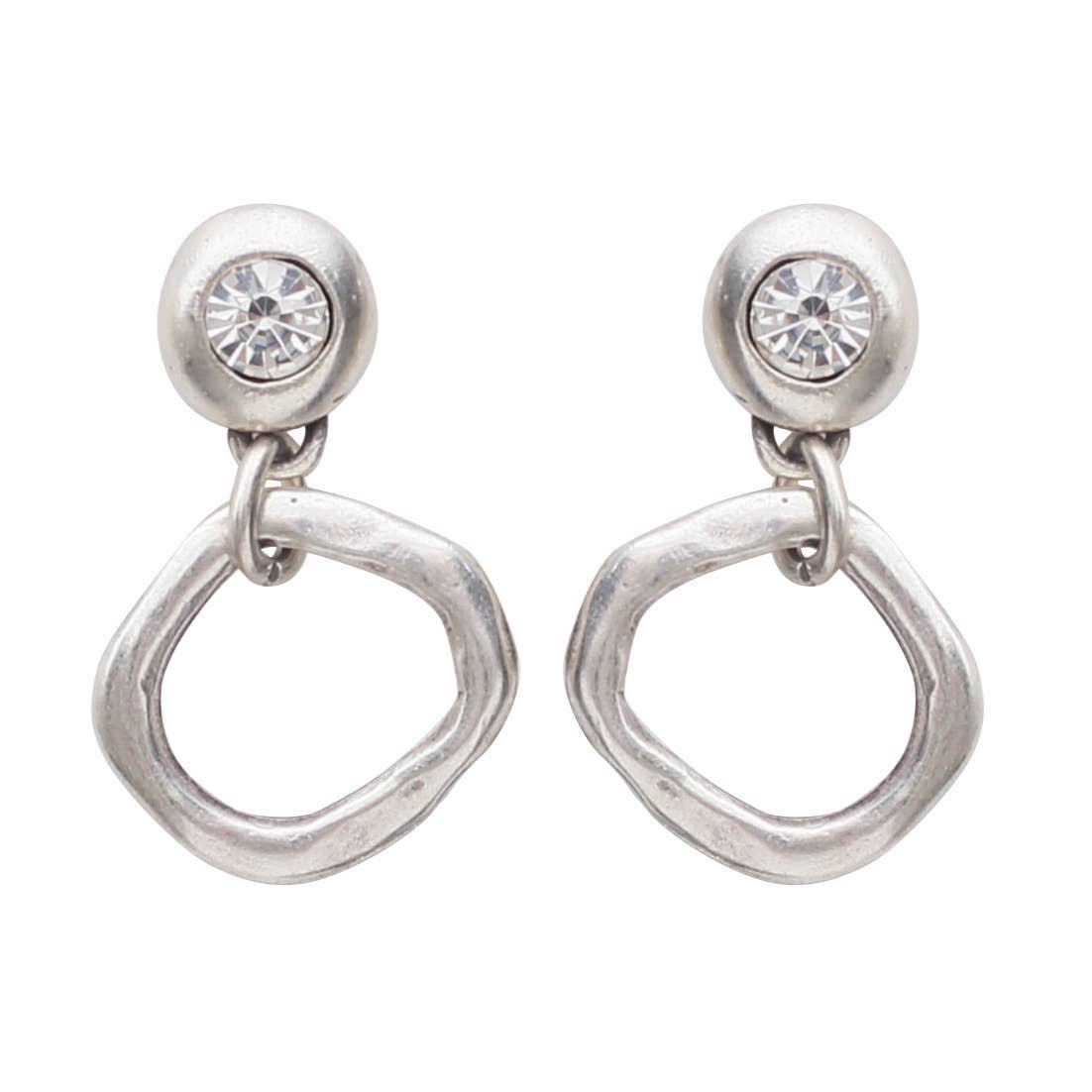 A pair of silver-toned dangle earrings with a round bezel-set clear crystal stud and an organic, wavy open circular drop, shown on a plain white background.