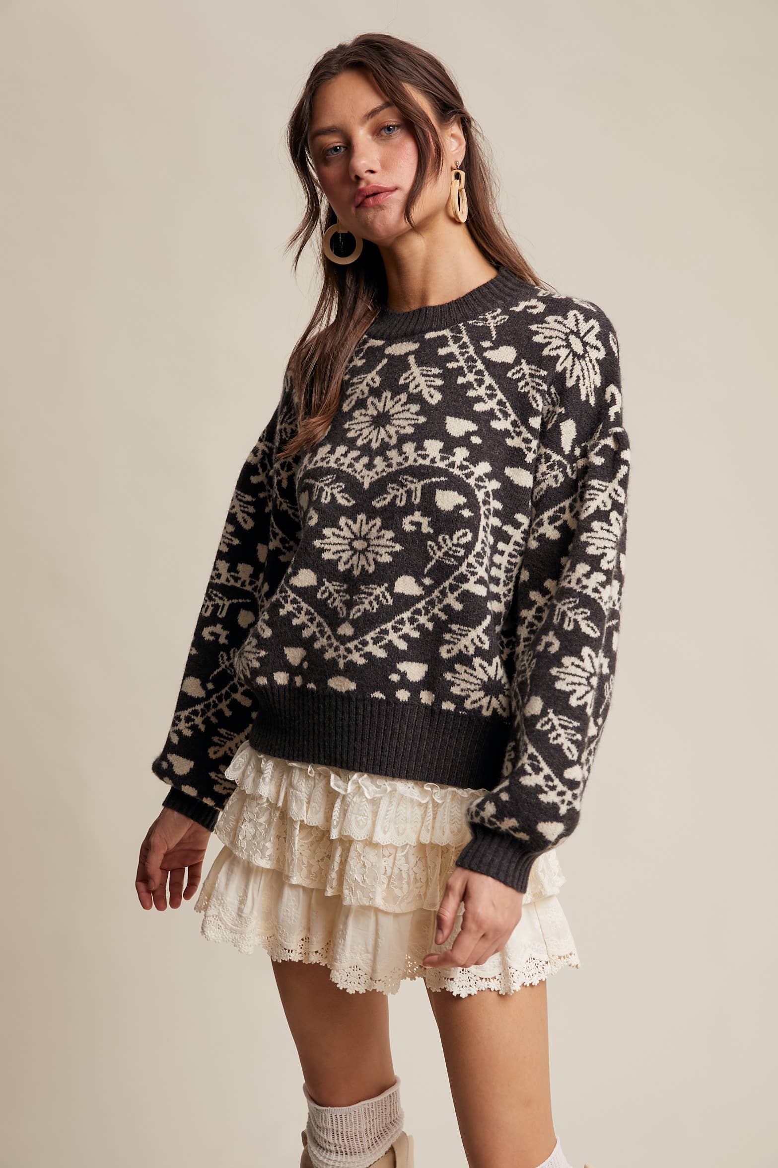 Charcoal crewneck sweater with cream floral heart–motif jacquard, puff sleeves, and ribbed cuffs and hem.