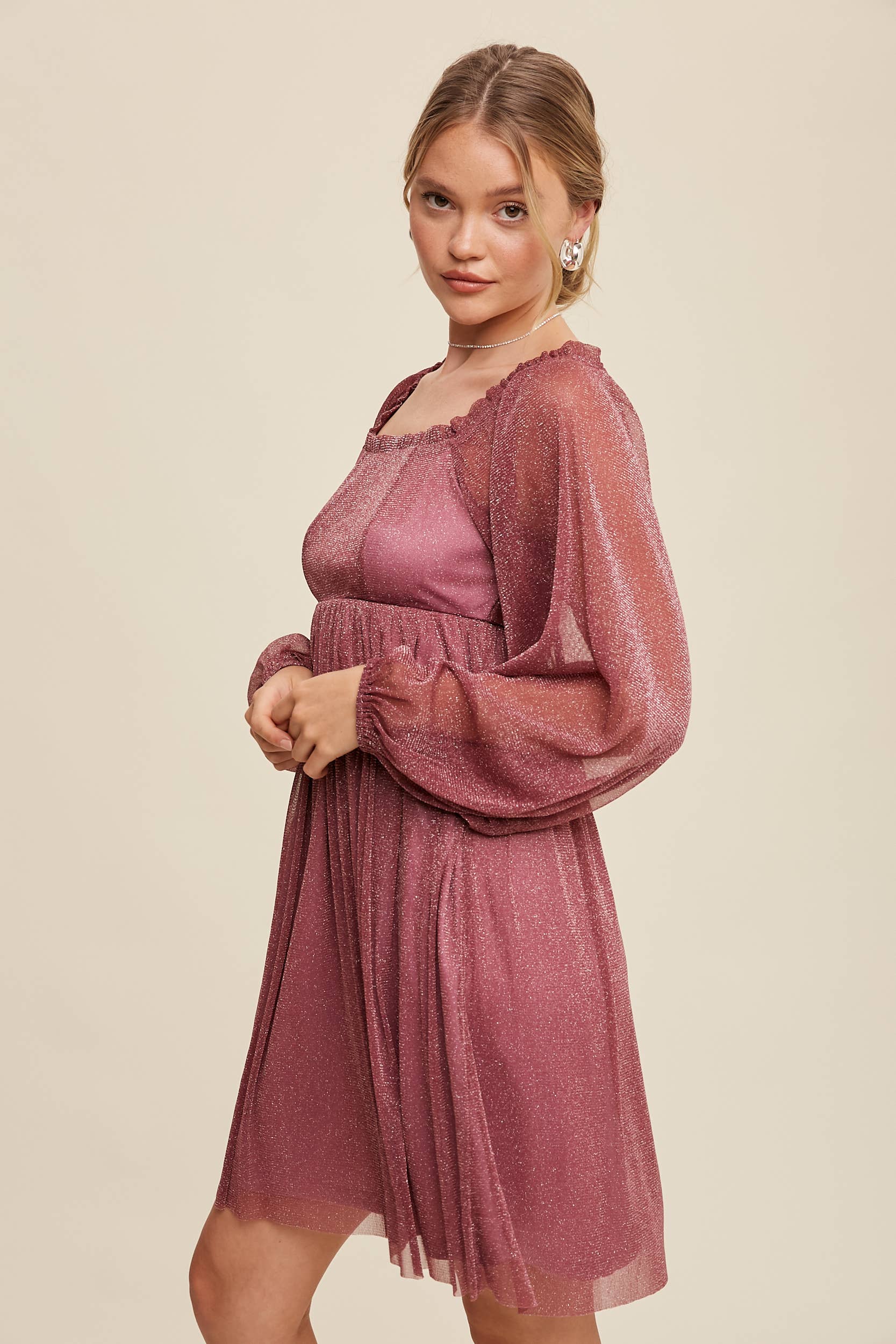 Model wearing a mauve shimmer mini dress with long sheer sleeves, square neckline, and flowy A-line silhouette — romantic sparkle party dress