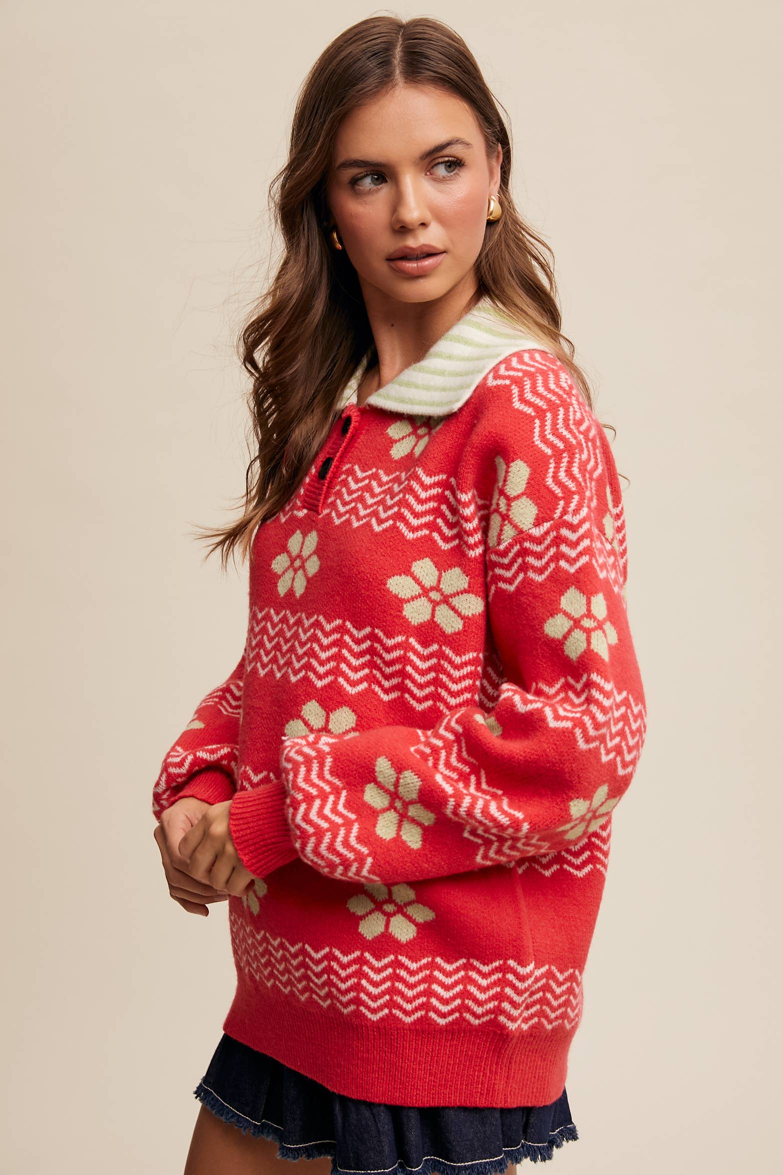 Woman wearing a red sweater with white patterns on a beige background