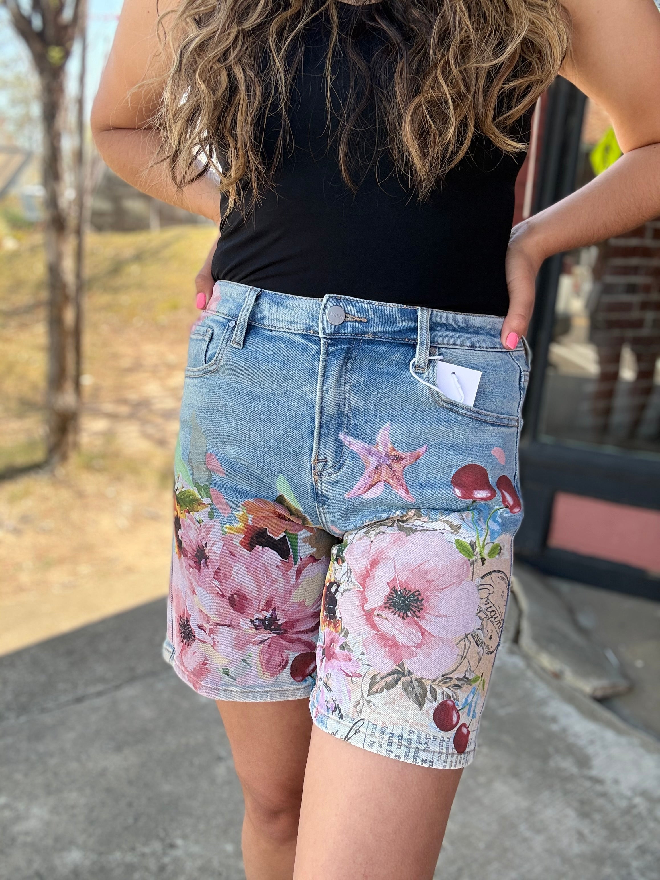 Person wearing floral shorts with a blurred background