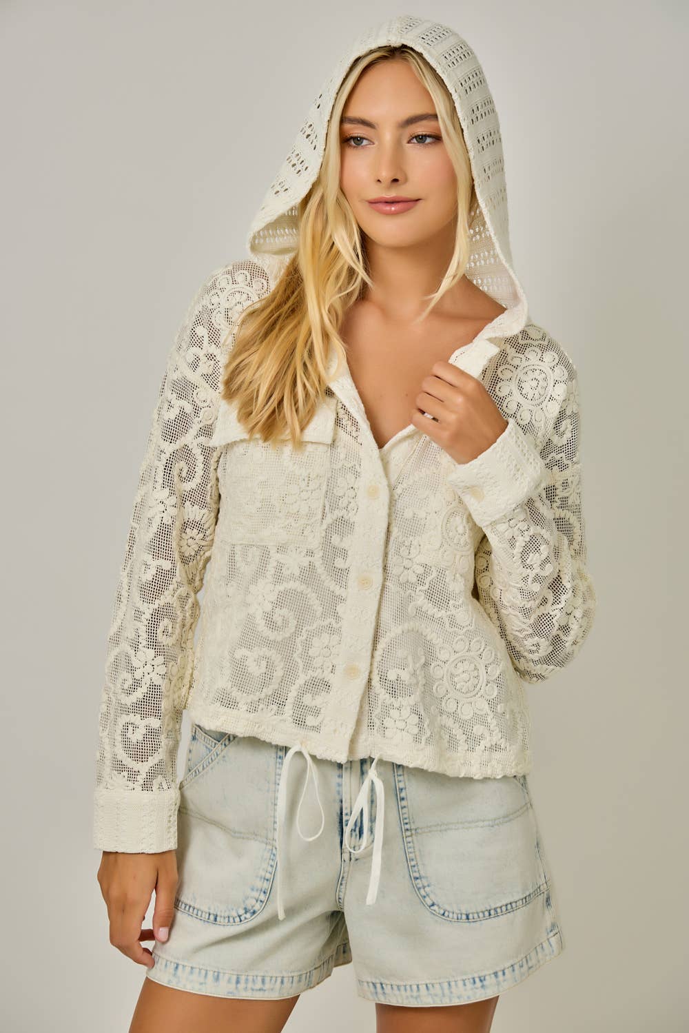 Crochet Lace Drawstring Hoodie Jacket in Ivory — button-down front, chest pockets, drawstring waist, and long sleeves in delicate crochet lace showing hoodie on model