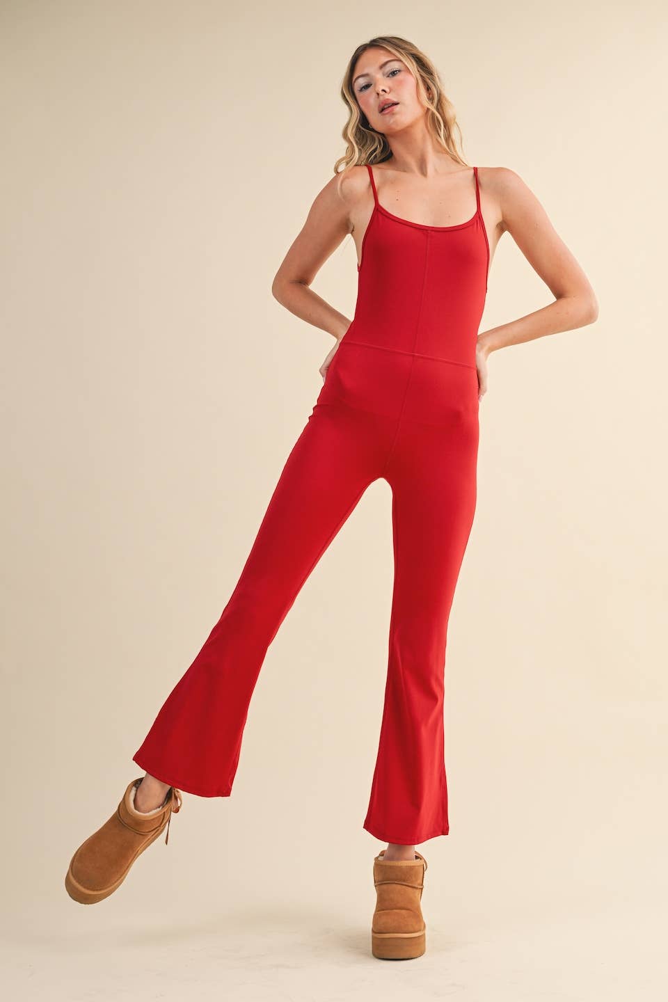Rear view of Woman wearing Kimberly C flare jumpsuit in cherry red with scoop neckline and flared leg.