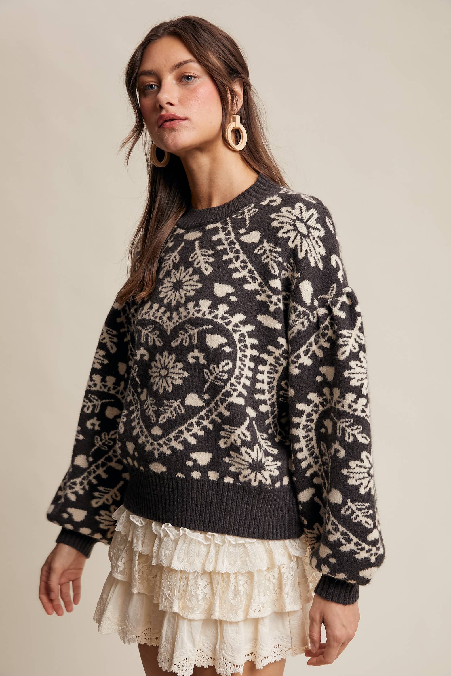 Charcoal crewneck sweater with cream floral heart–motif jacquard, puff sleeves, and ribbed cuffs and hem.