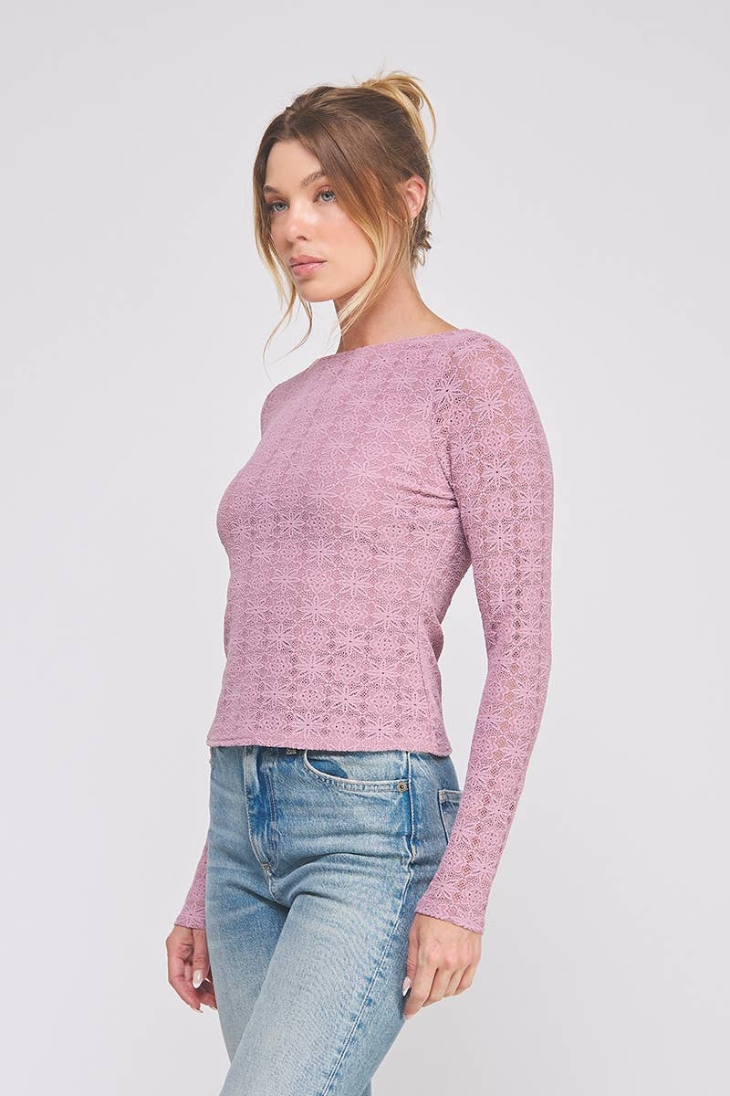 Woman wearing a orchid pink top with lace details and blue jeans on a white background