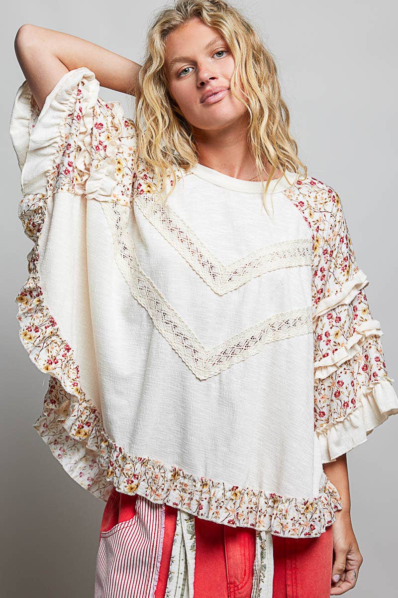 Tina's Boho Floral Lace Top in Natural – front view, natural knit body with cream crochet lace chevron trim and pink floral ruffle sleeves, styled with red patchwork pants