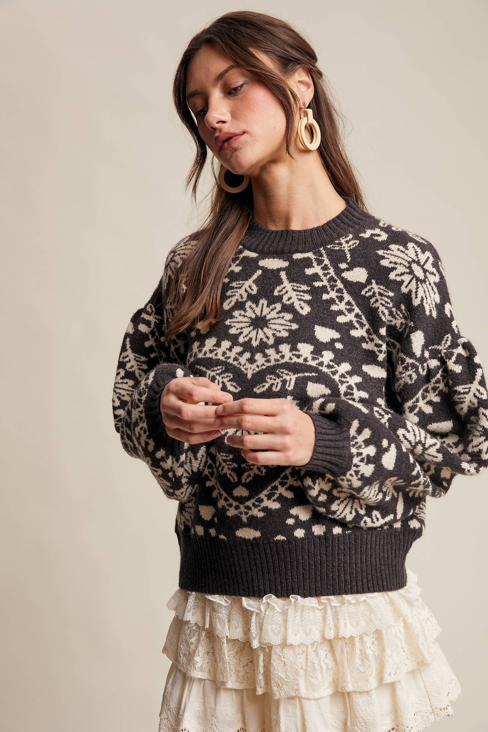 Charcoal crewneck sweater with cream floral heart–motif jacquard, puff sleeves, and ribbed cuffs and hem.
