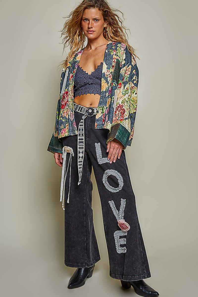 Full view of a woman wearing the Peace in Bloom green floral reversible boho jacket ⠋