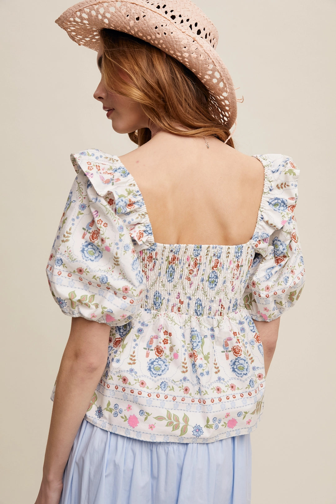 Woman wearing a floral patterned crop top with puff sleeves