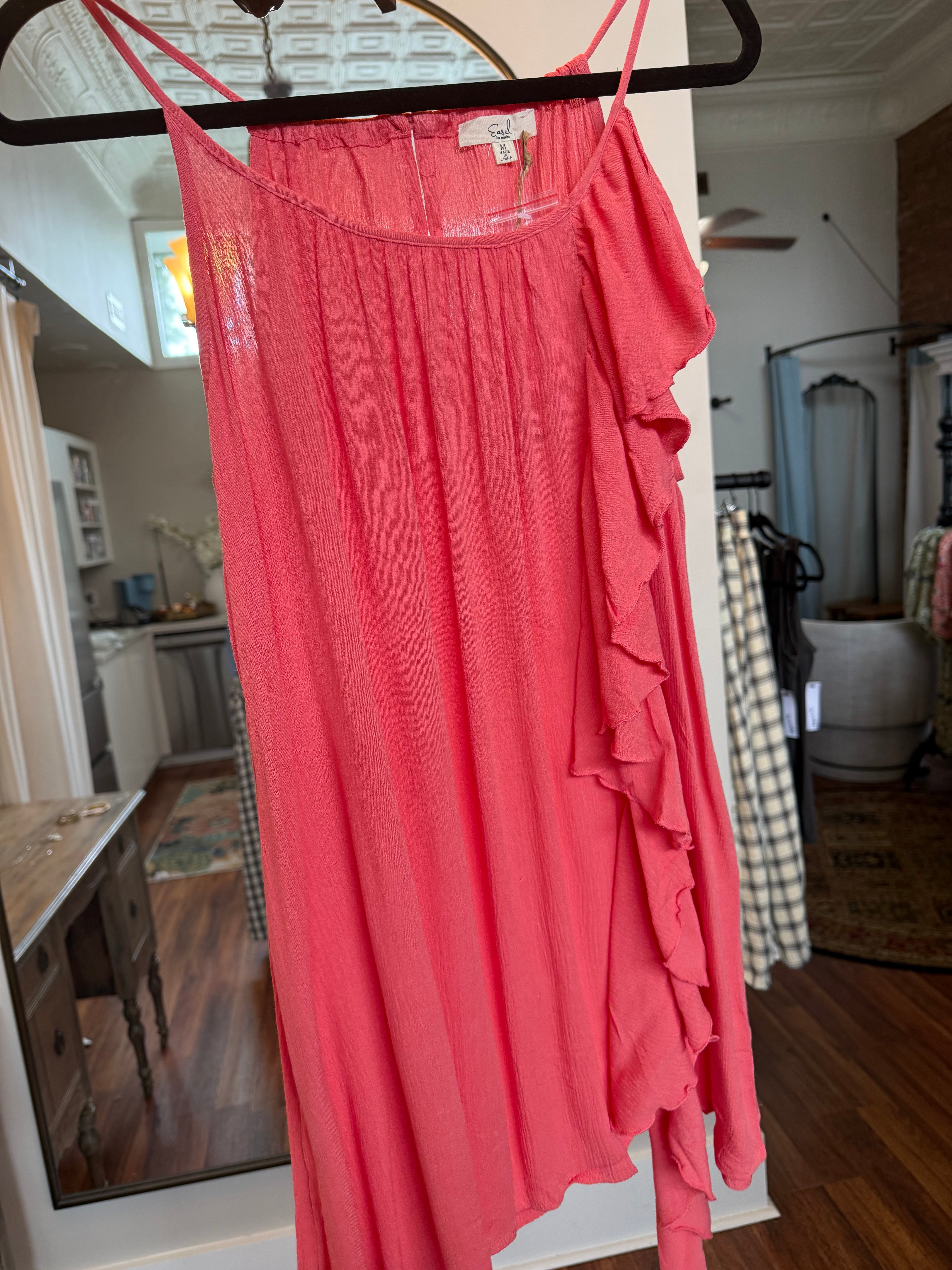 Red dress on a hanger with a blurred indoor background
