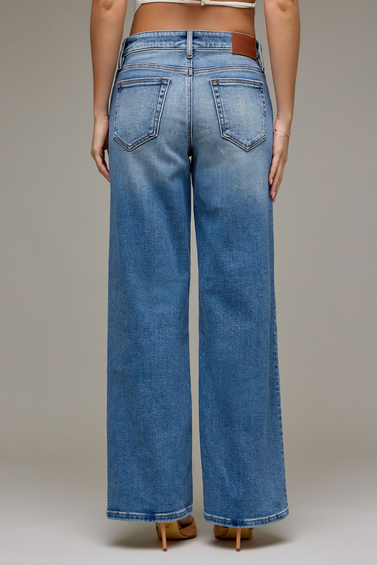 Back view of Everyday Ease Mid Rise Dad Jeans in light-wash denim, showing two back pockets, relaxed wide legs, and raw hems.