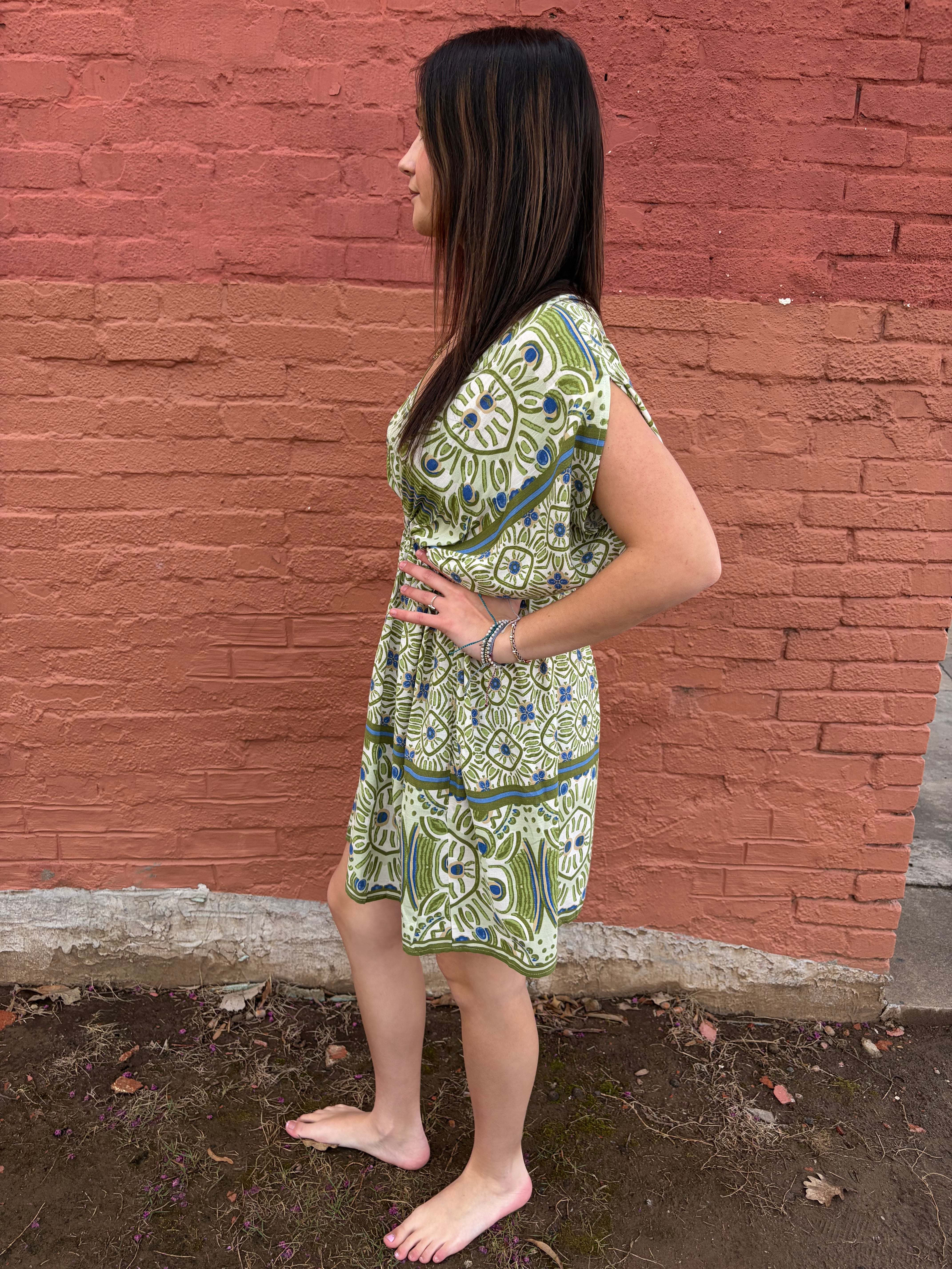 Side view of model wearing the green Haydee Mini Dress