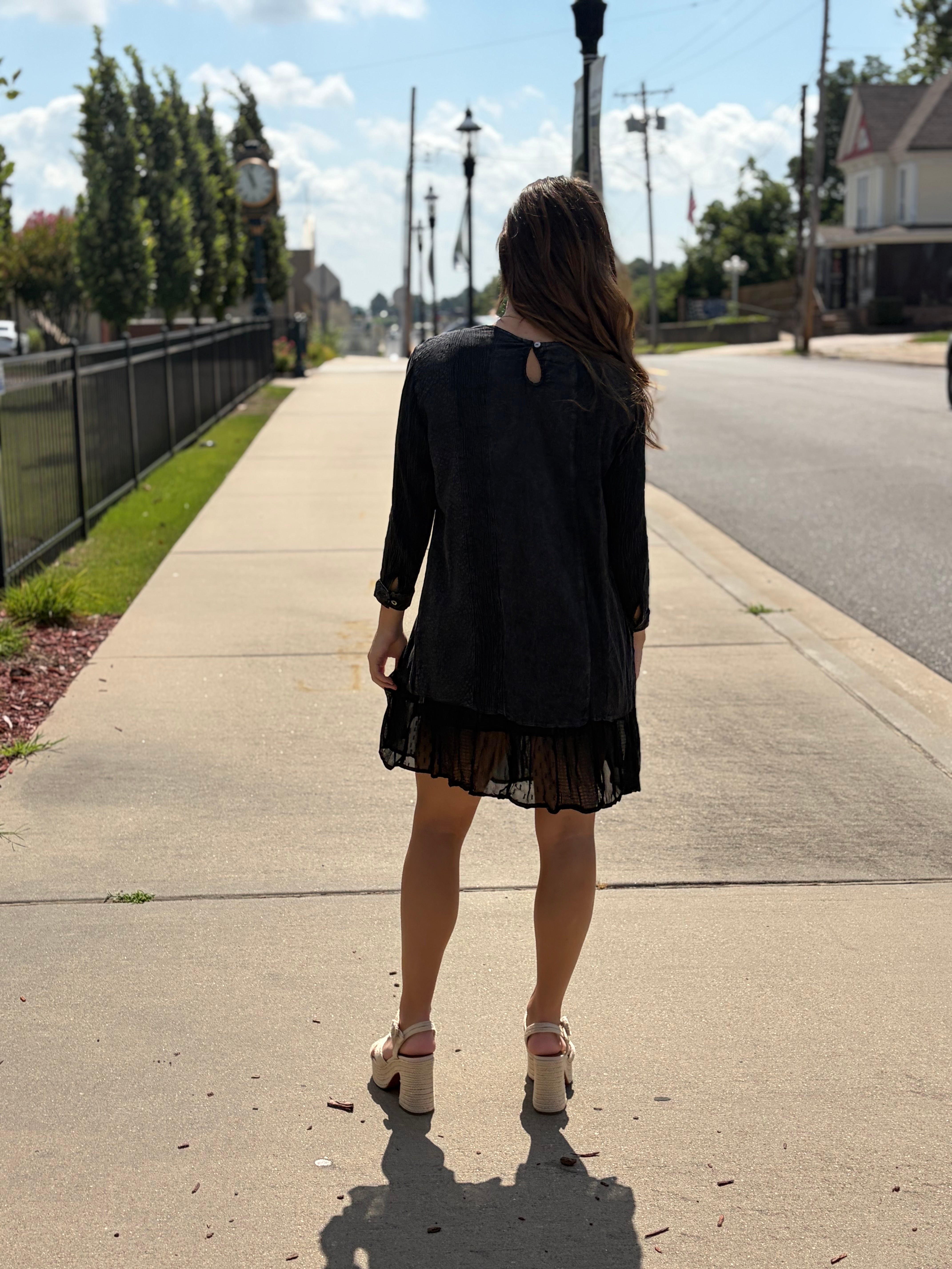 Back view of black sable embroidered babydoll dress showing keyhole neckline detail and ruffle hem