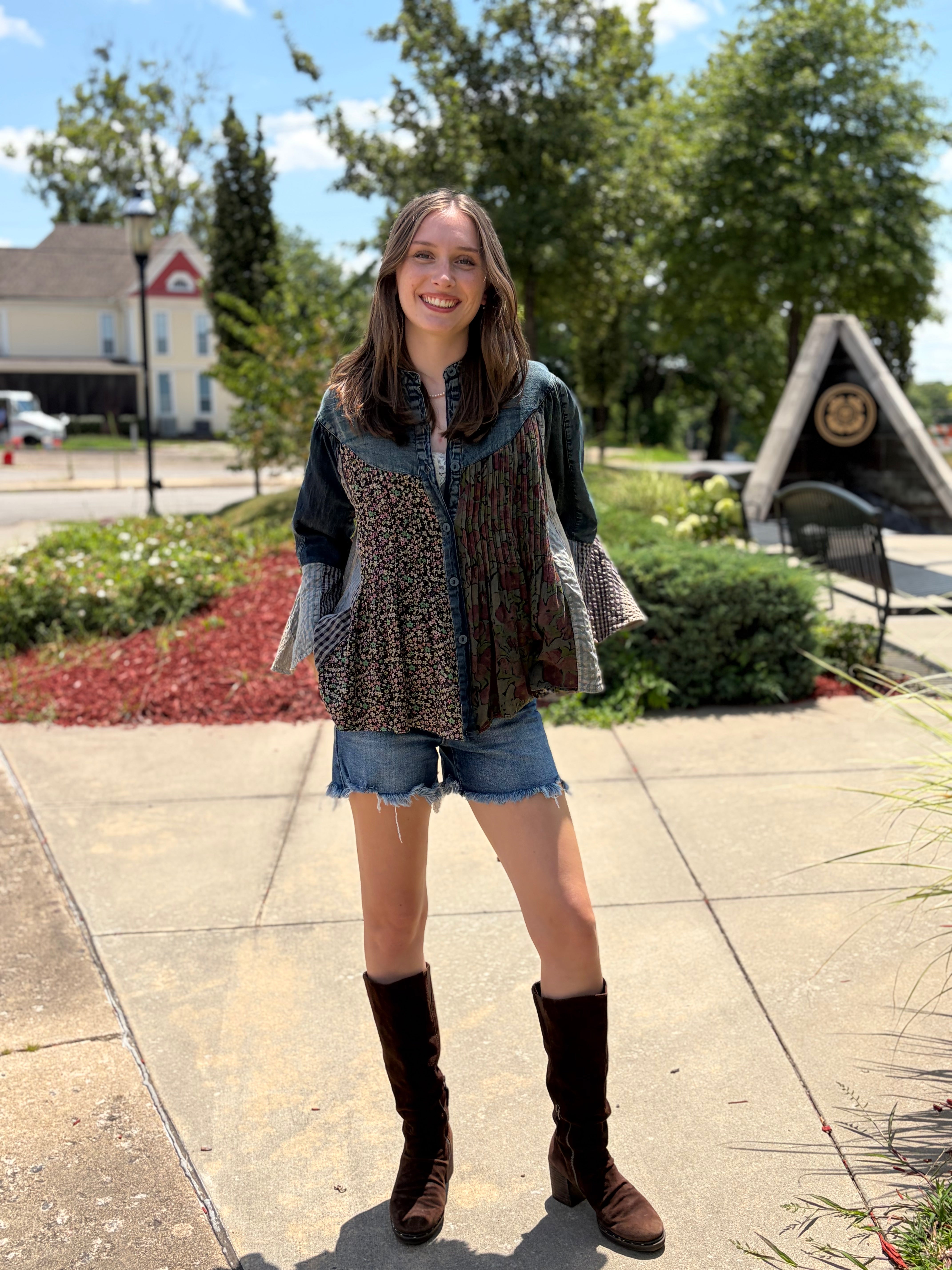 Outdoor full-body front, smiling model, denim shorts + tall brown boots