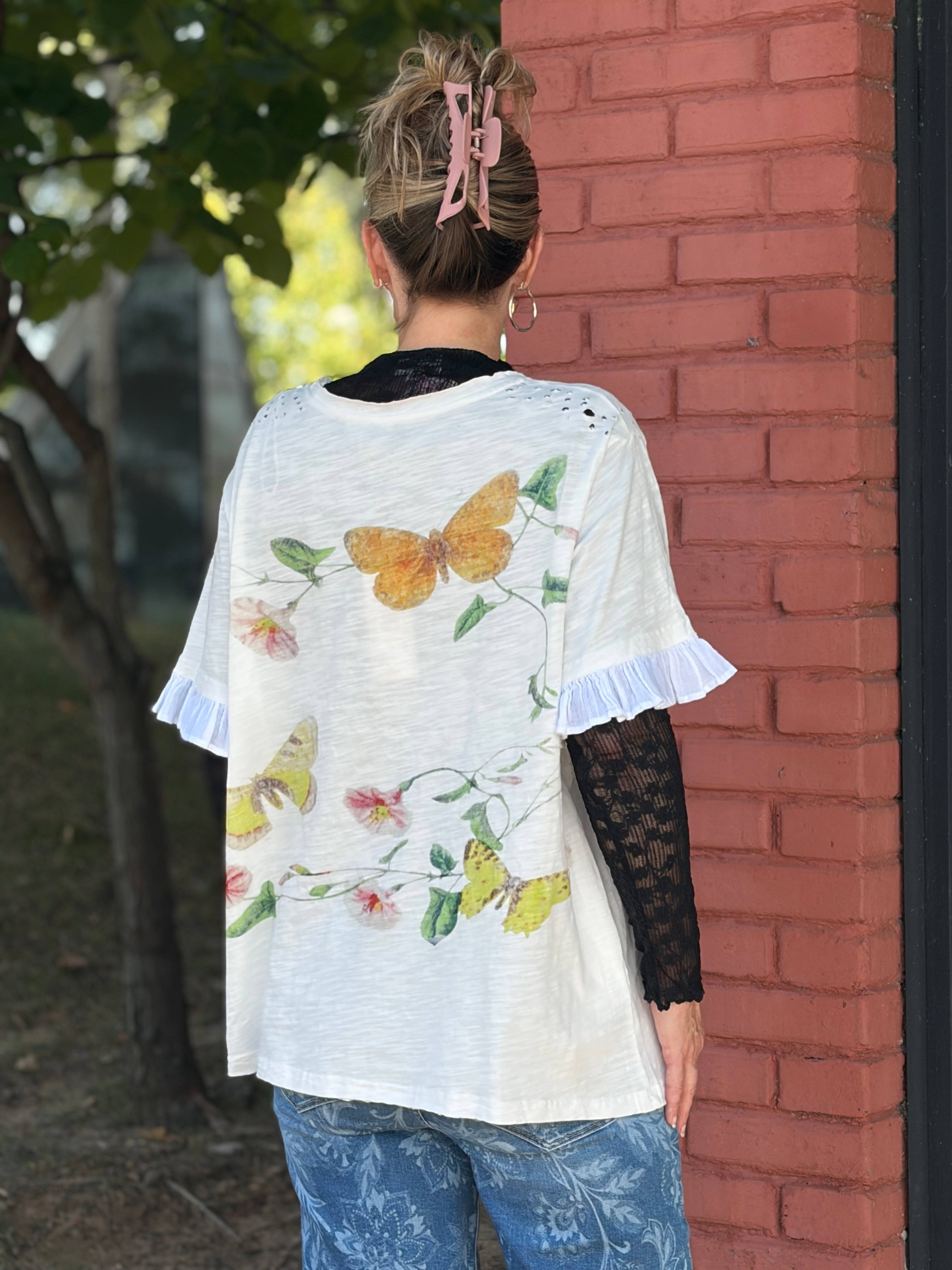 Back view of white butterfly botanical print top with ruffle sleeves and all-over floral print on mineral-washed fabric — Spirit & Wind Boutique