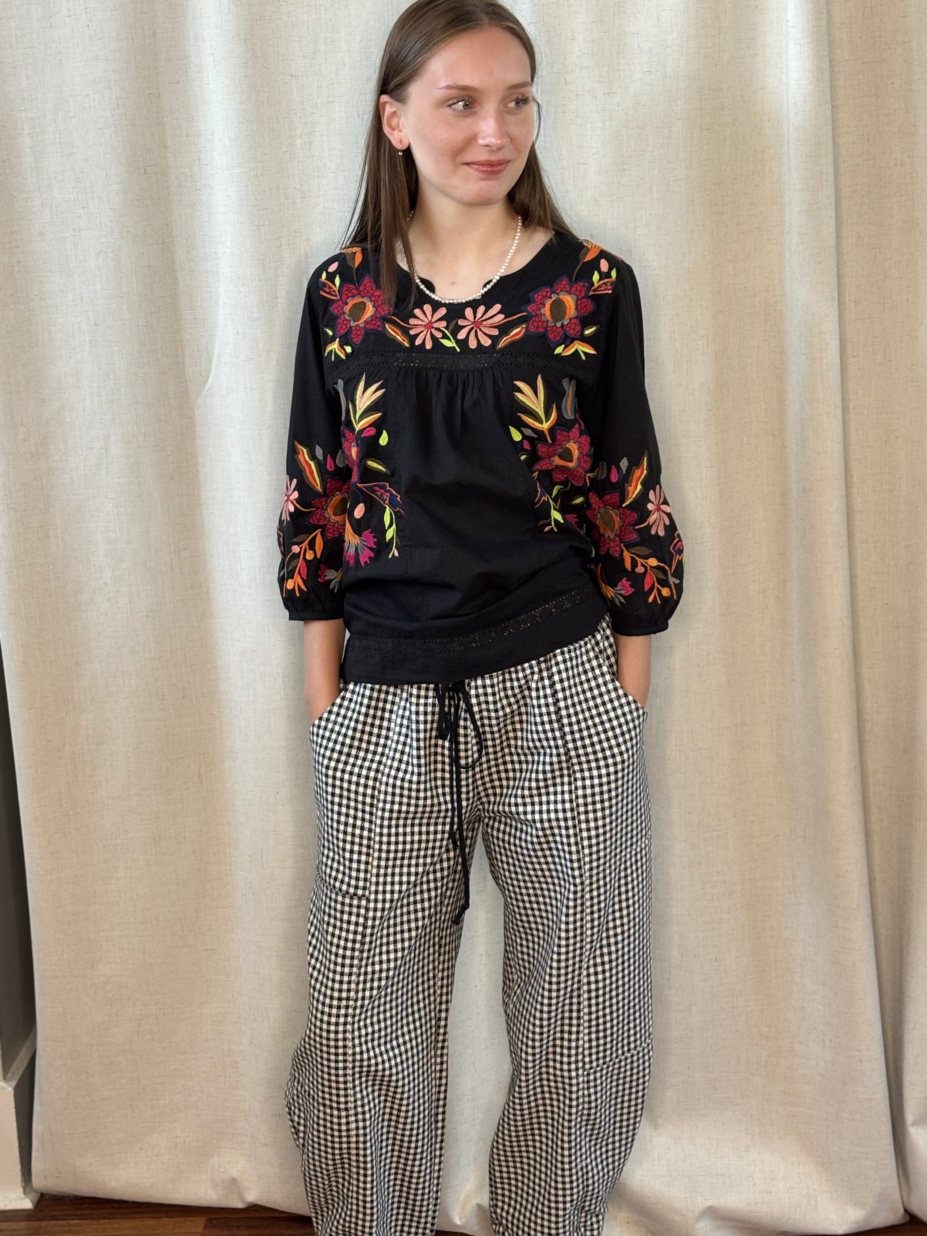 Model wearing NOABOA Mini Plaid Cuffed Barrel Pants with a black floral embroidered boho blouse, full-length front view