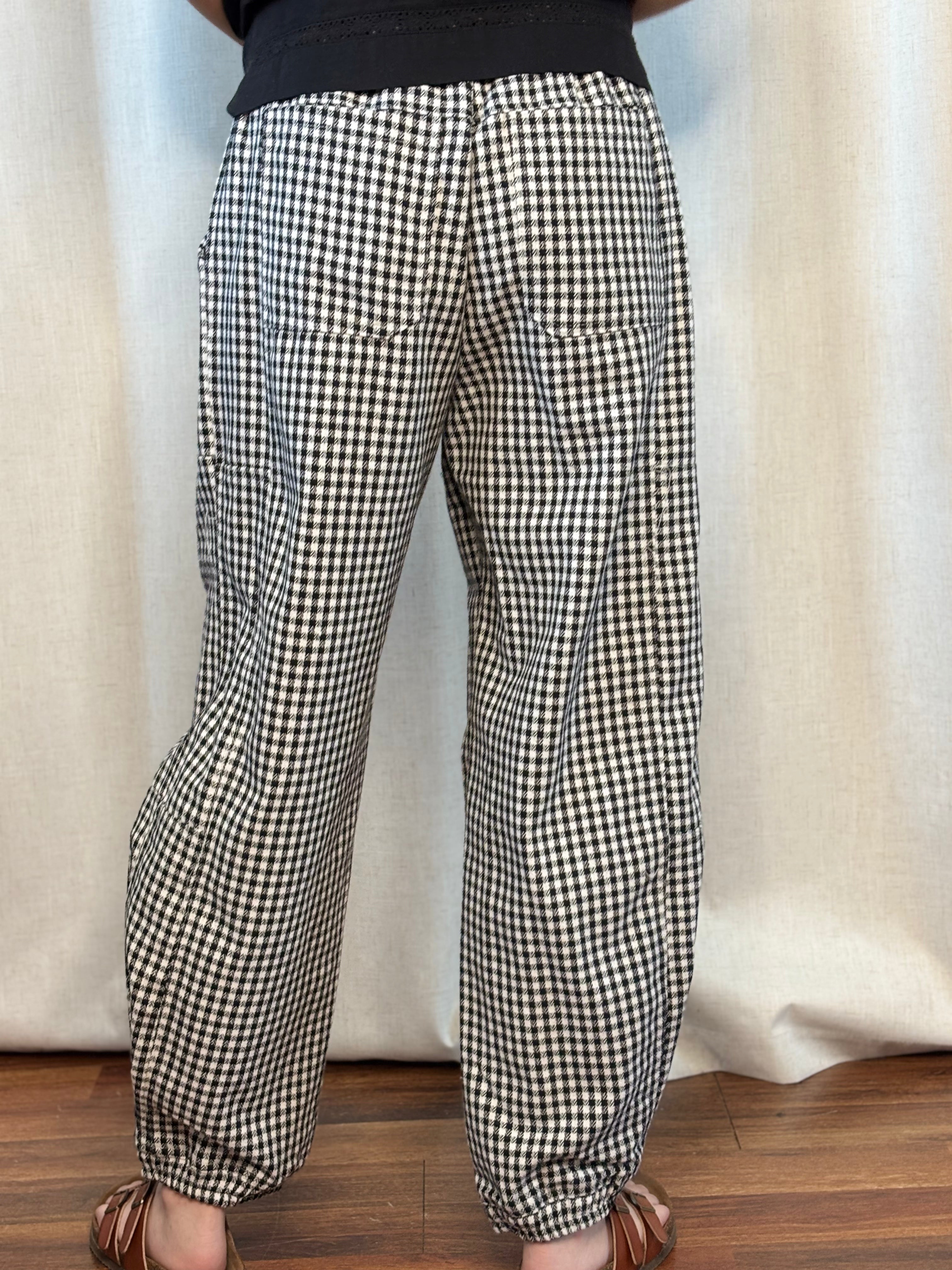 Back view of NOABOA Mini Plaid Cuffed Barrel Pants showing barrel-leg silhouette, cuffed hem, and back patch pockets in black and white houndstooth