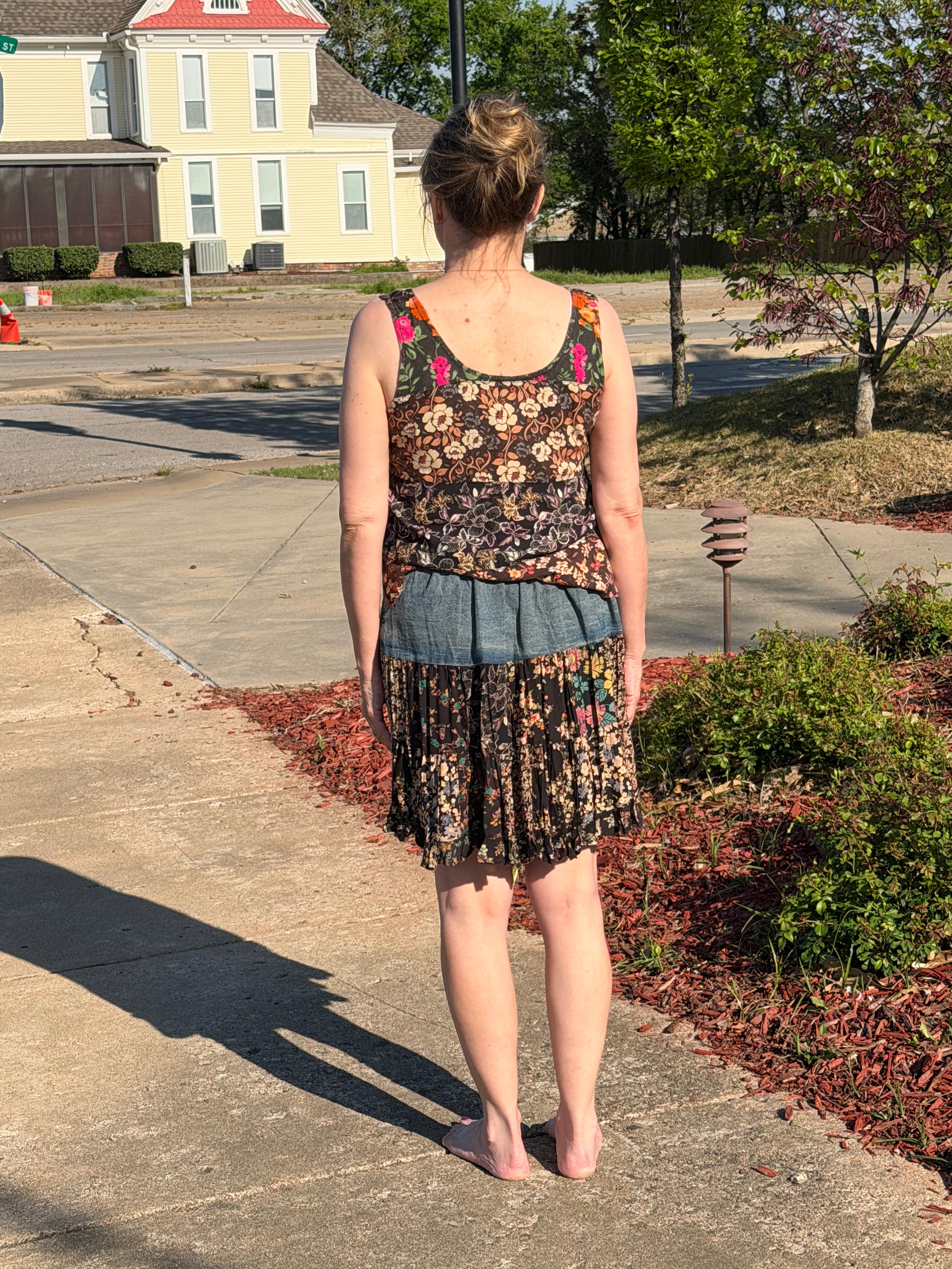 Back view of Boho Patchwork Denim Set – Sleeveless floral patchwork denim tank that has rayon print mini skirt with pockets | Spirit & Wind Boutique