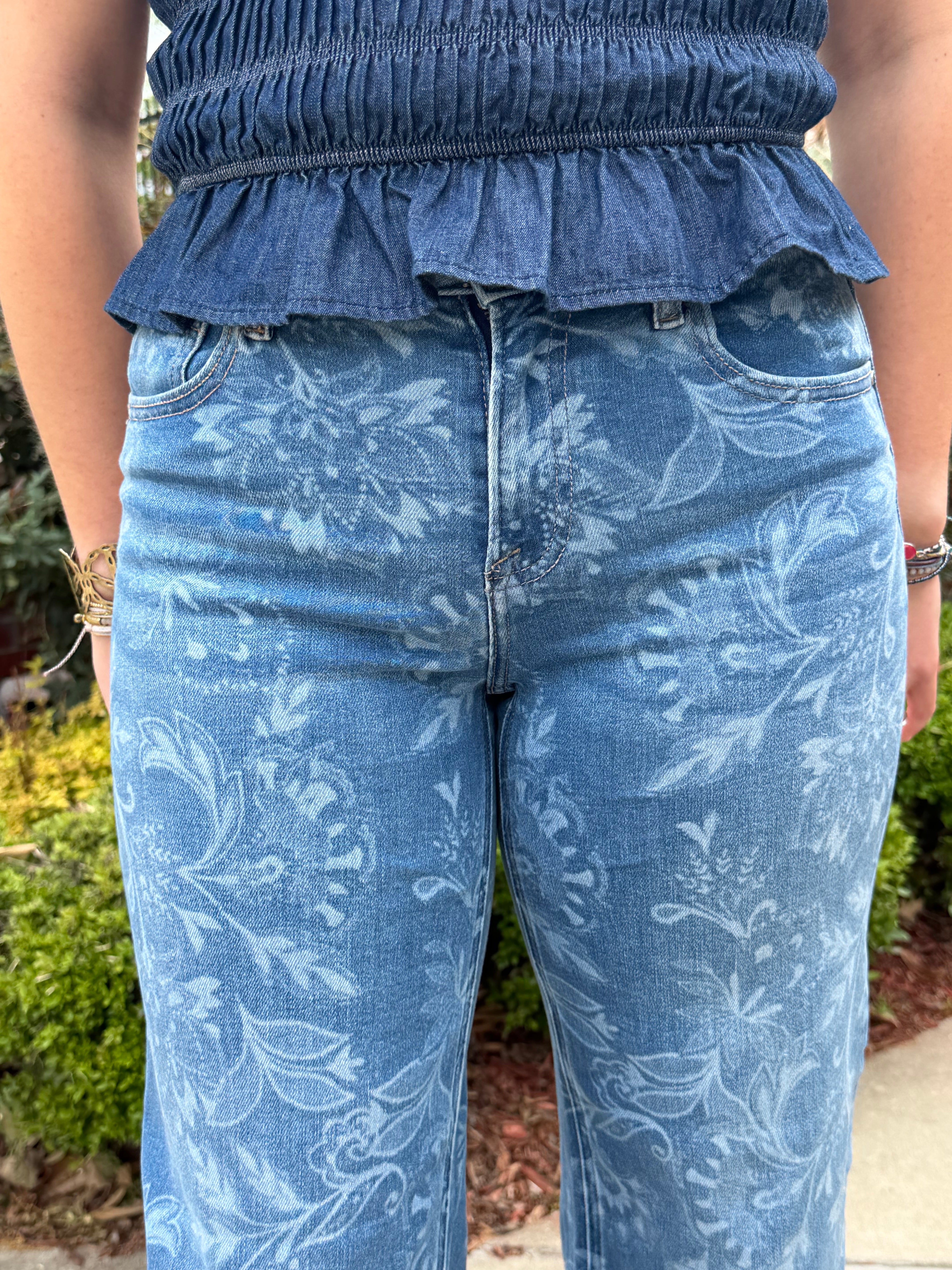 Close-up of blue floral-patterned jeans with a blurred background