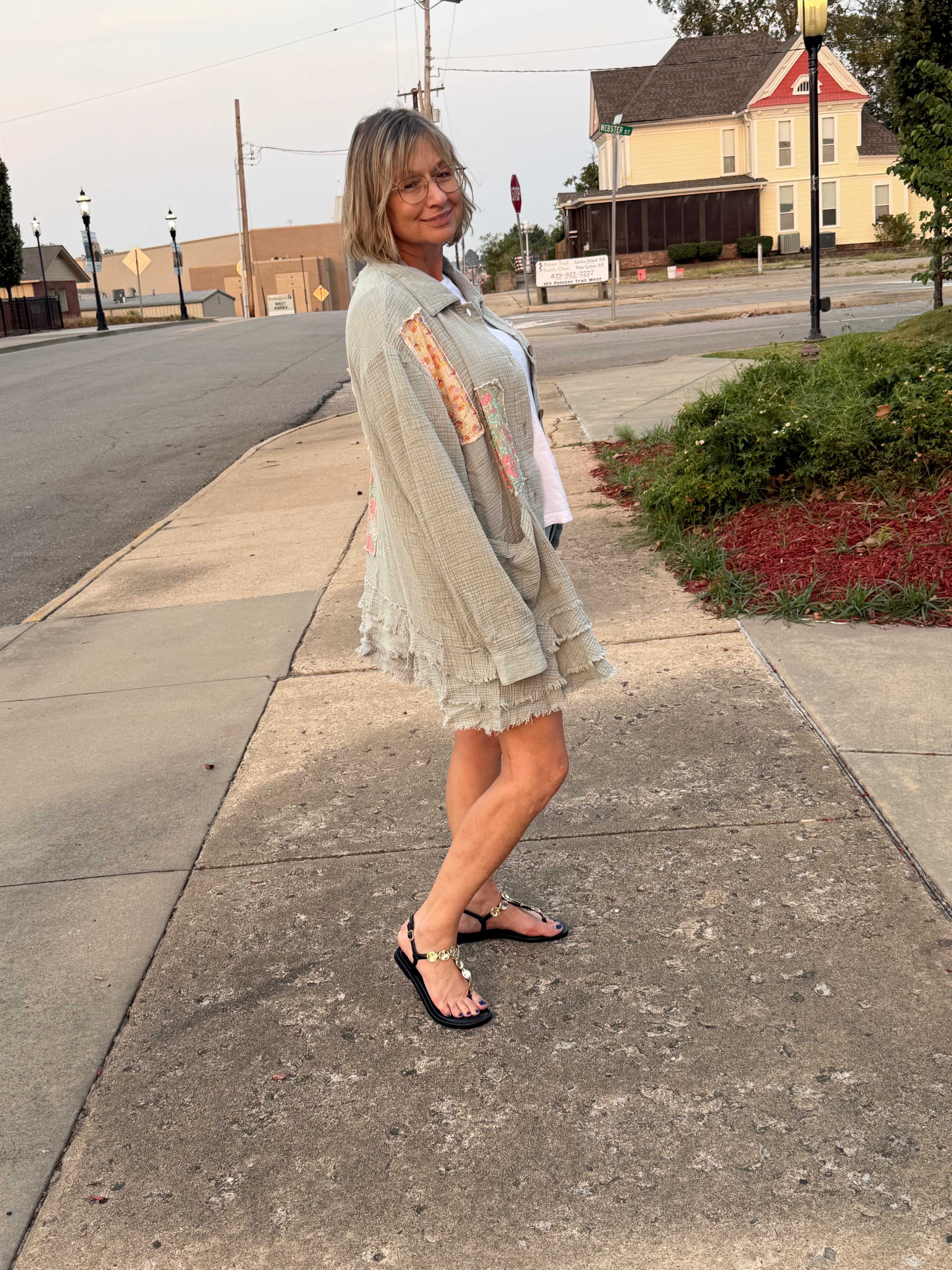 Side profile view of woman wearing Blue Velvet sage patchwork ruffle hem gauze shirt showing layered tiered hem and relaxed oversized fit