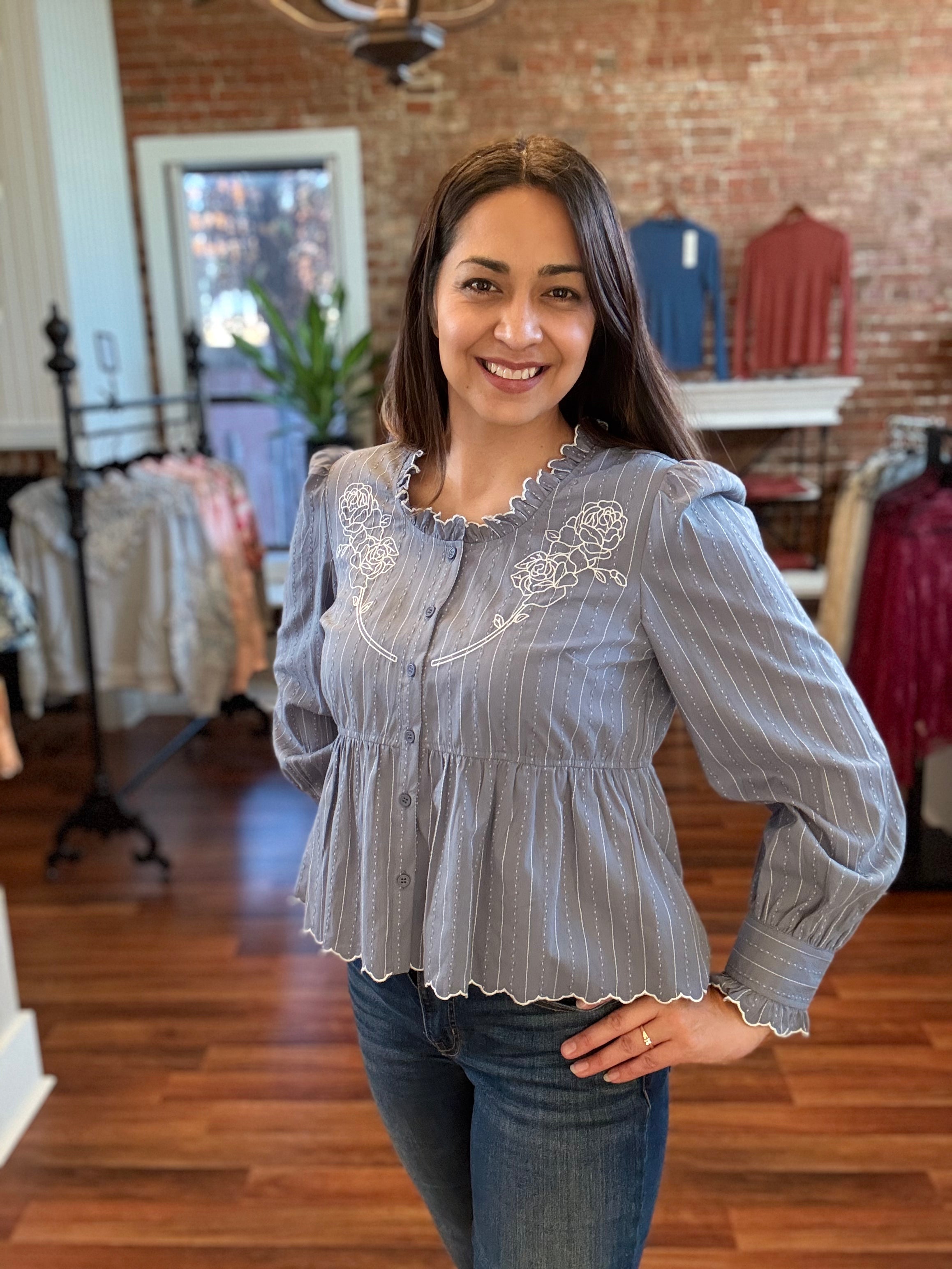 Woman wearing a blue ruffle embroidered long sleeve blouse