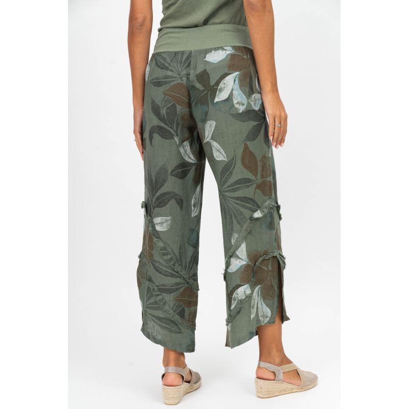 Green leaf-patterned pants worn by a person on a white background