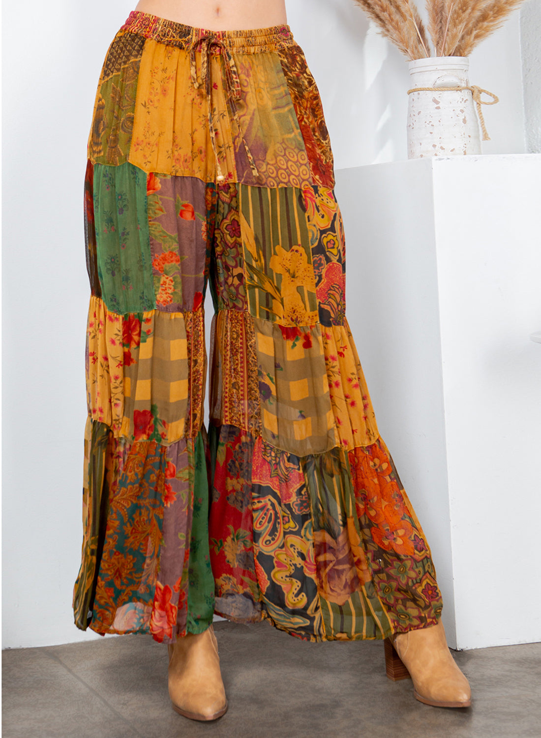 Colorful patchwork pants worn by a person with a white background