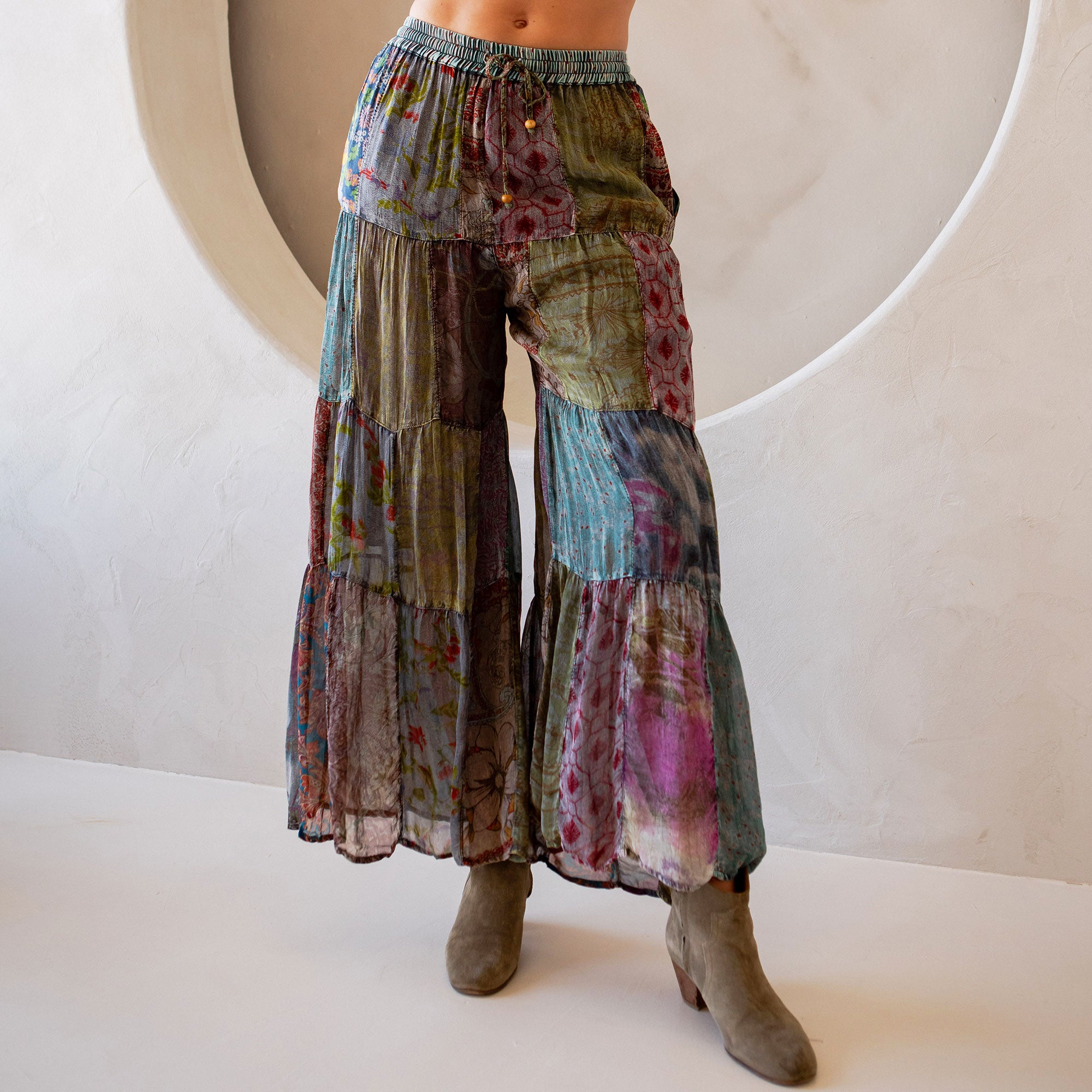 Multicolored patchwork pants worn by a person on a white background