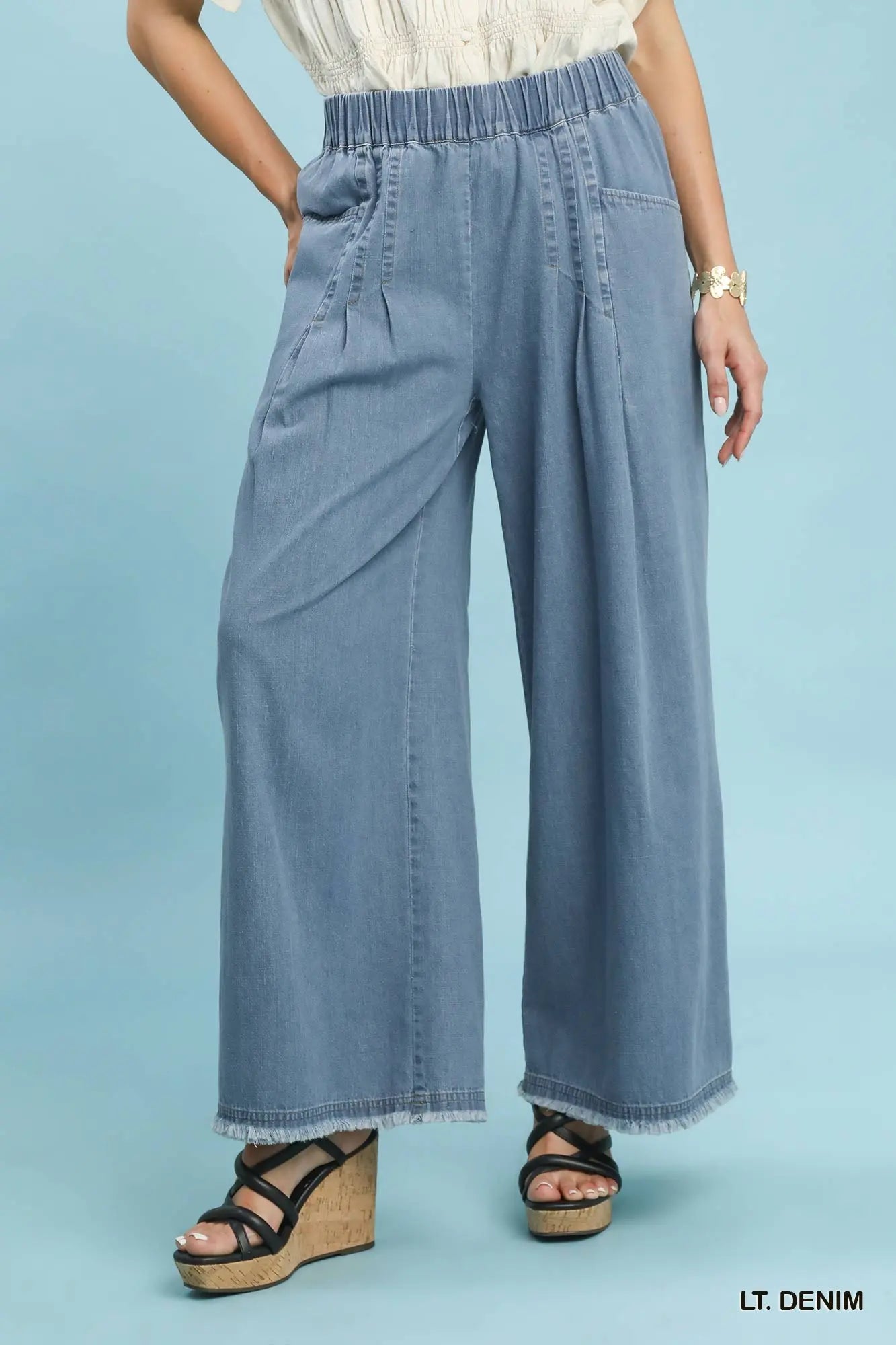 Light blue denim wide-leg pants worn by a person on a light blue background