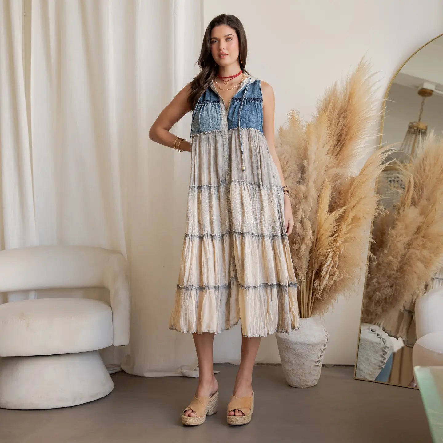 A woman wearing a tired denim and latte dress