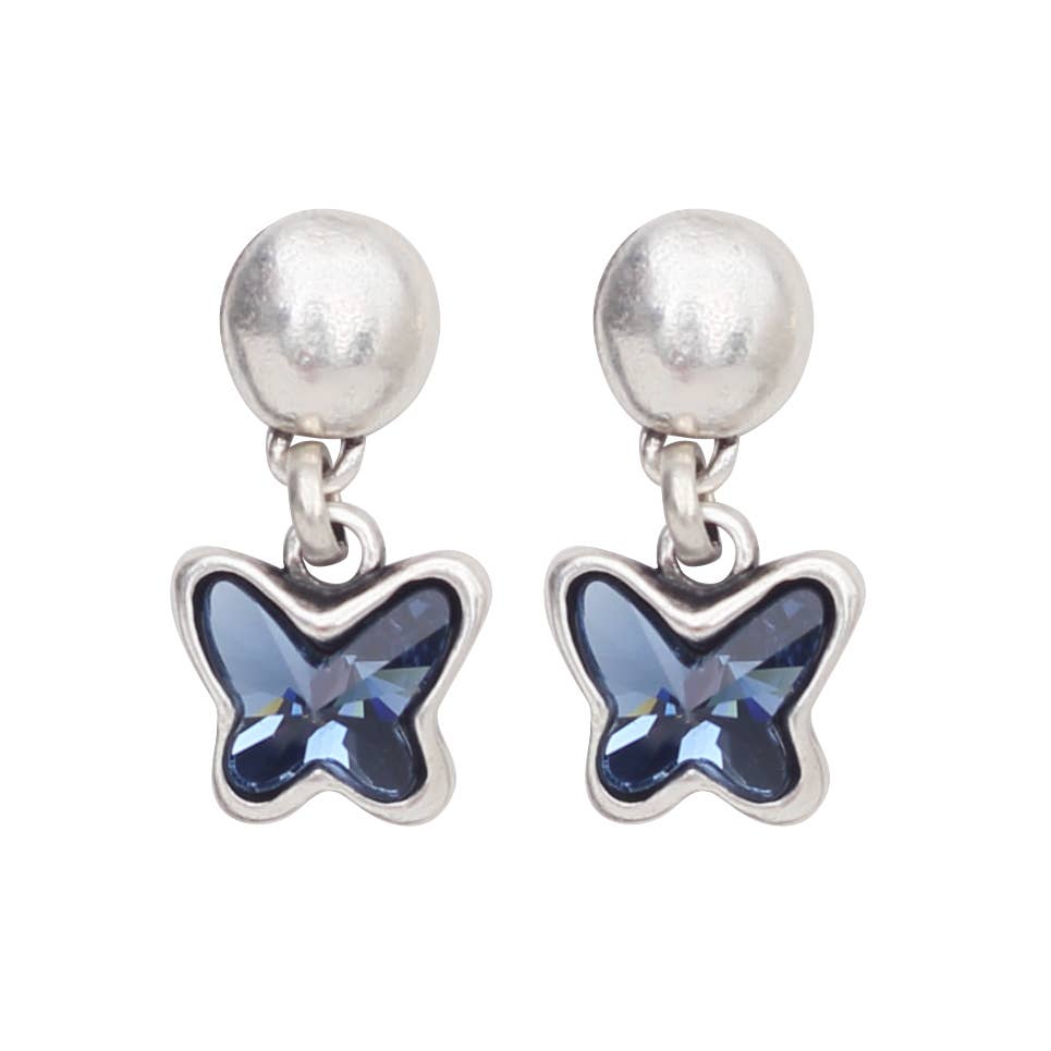A pair of silver dangle earrings featuring a faceted blue butterfly-shaped crystal hanging from a textured silver ball stud, shown on a plain white background.
