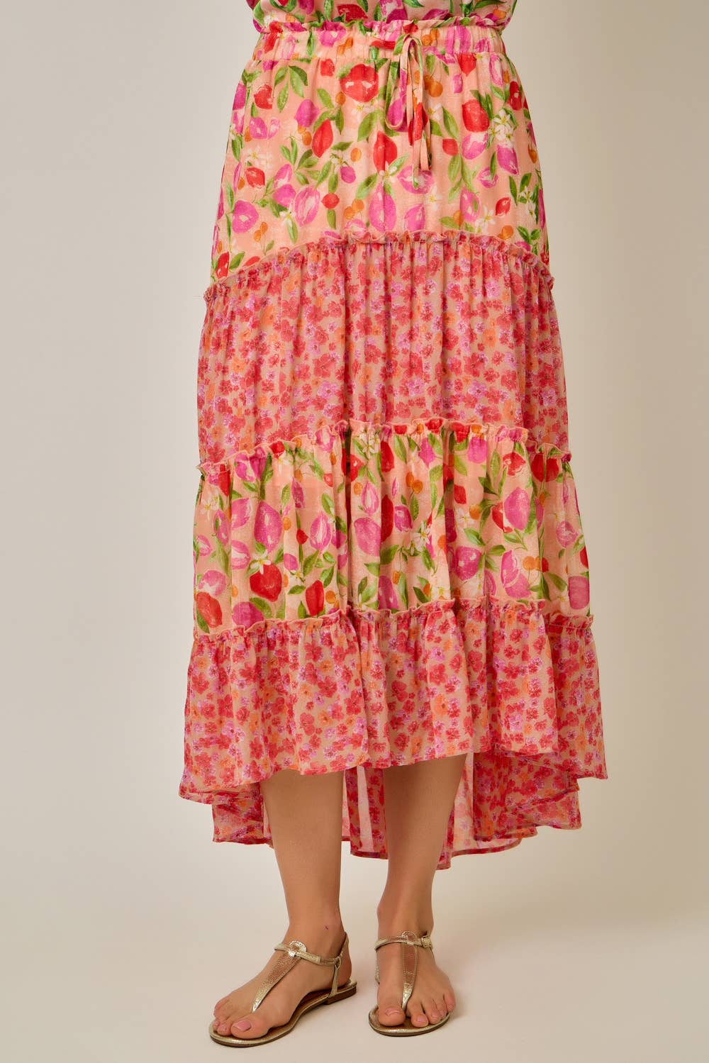 Woman wearing a colorful floral dress on a plain background
