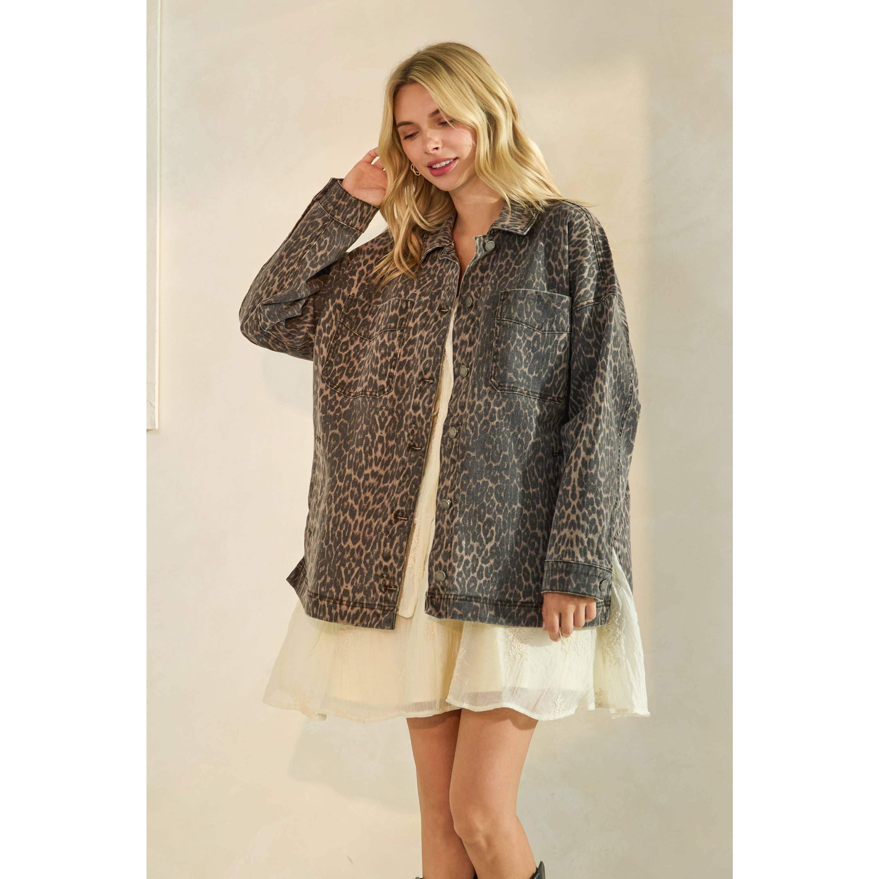 Oversized camouflage print jacket with front pockets and button closure, styled over a white tiered mini dress.