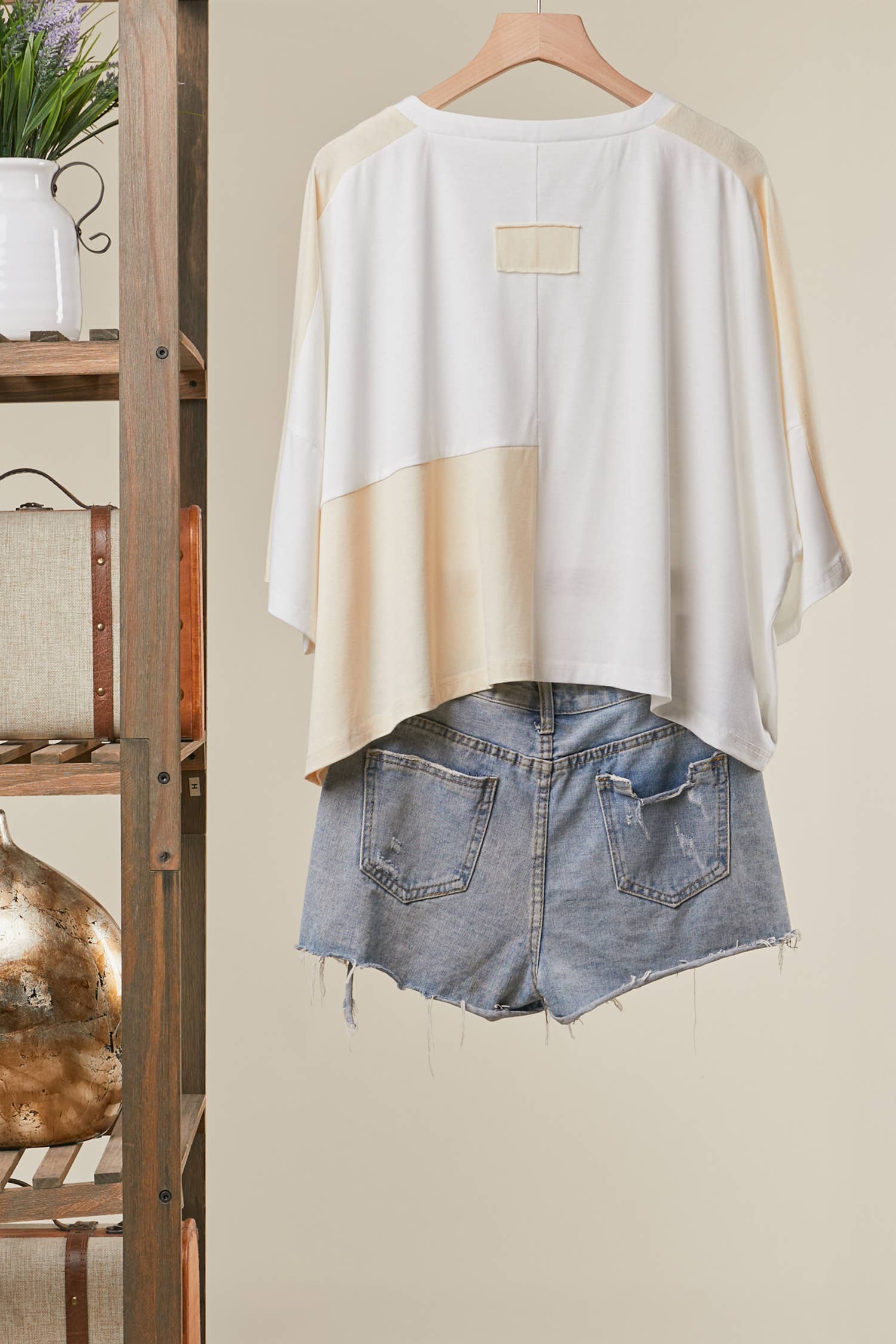 Back view of The Cleo Crochet Patchwork Top in Cream — oversized patchwork silhouette with crochet medallion patch and flower appliqué detail, boho-luxe ivory and cream colorblock top