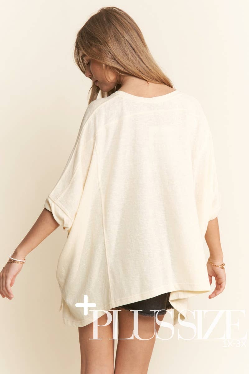 Woman wearing a white oversized shirt with 'Plus Size' text on a beige background