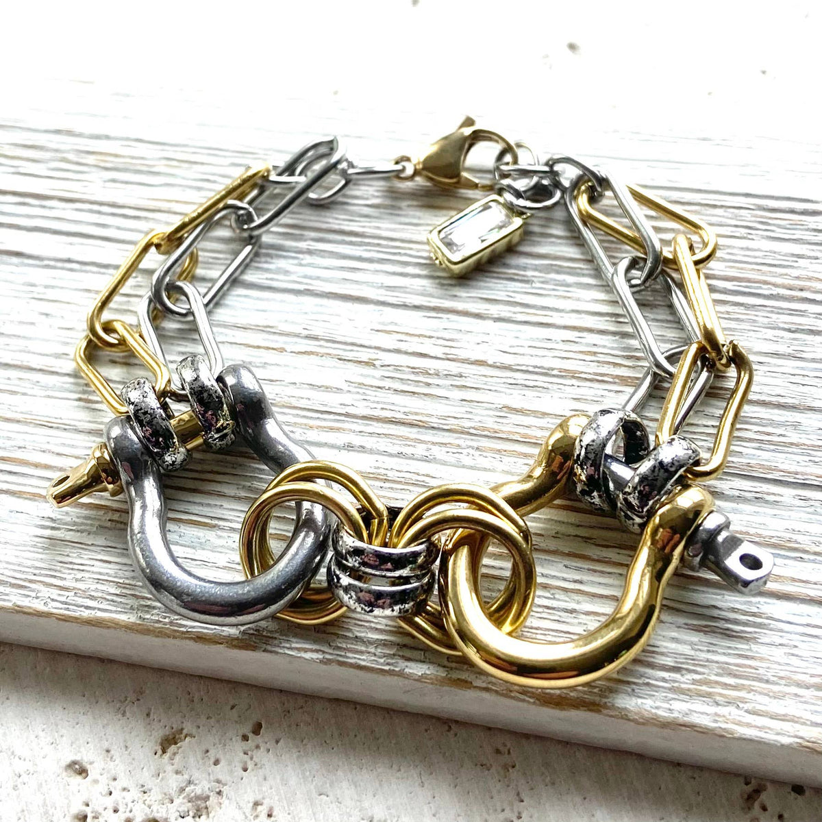 The Double Shackle Bracelet Mixed Metal pairs stainless steel chains with distinctive double-shackle detailing