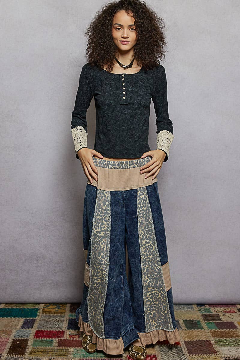 Woman wearing a dark blue and patterned dress with a beige belt against a plain background