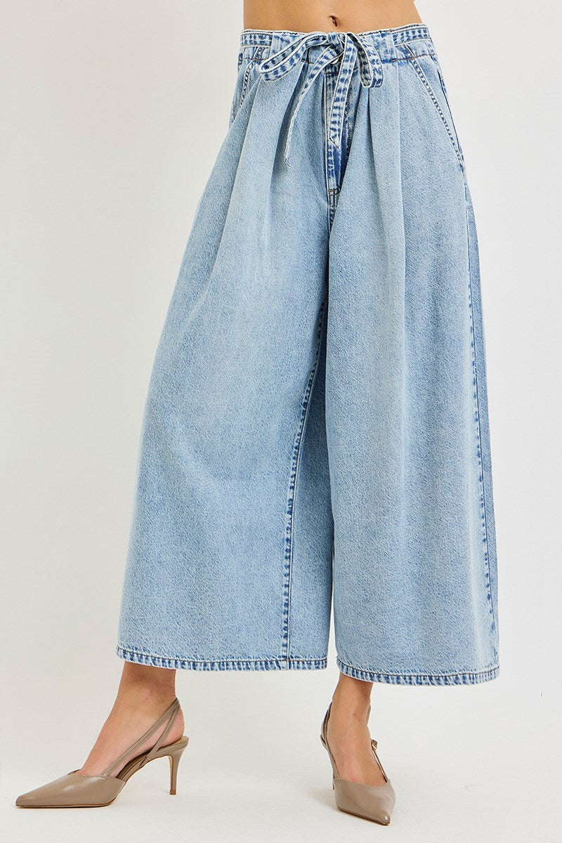 Light blue denim wide-leg pants with a tie waist on a plain background