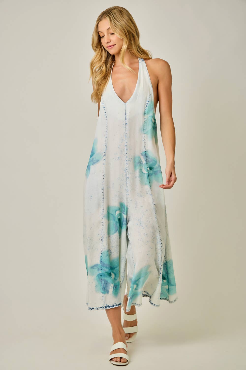Woman wearing a floral jumpsuit with a white background