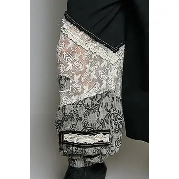 Leg close-up — mixed floral and scroll lace textures with ruffle trim