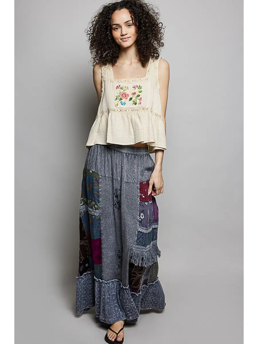 Full-body studio shot, curly-haired model, cream floral embroidered tank + black sandals