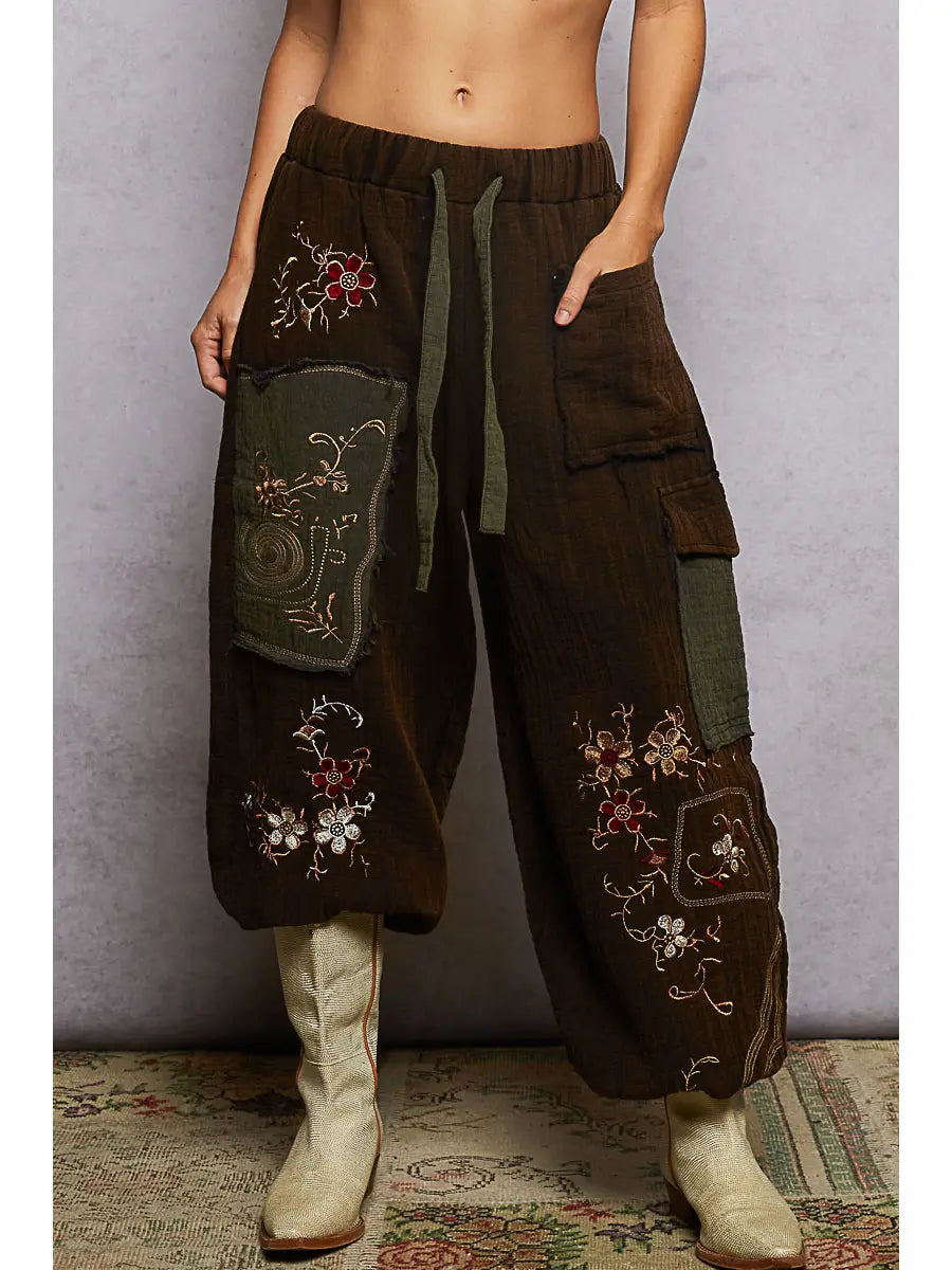 Front view, floral embroidery + olive patch pockets + drawstring waist + cream cowboy boots