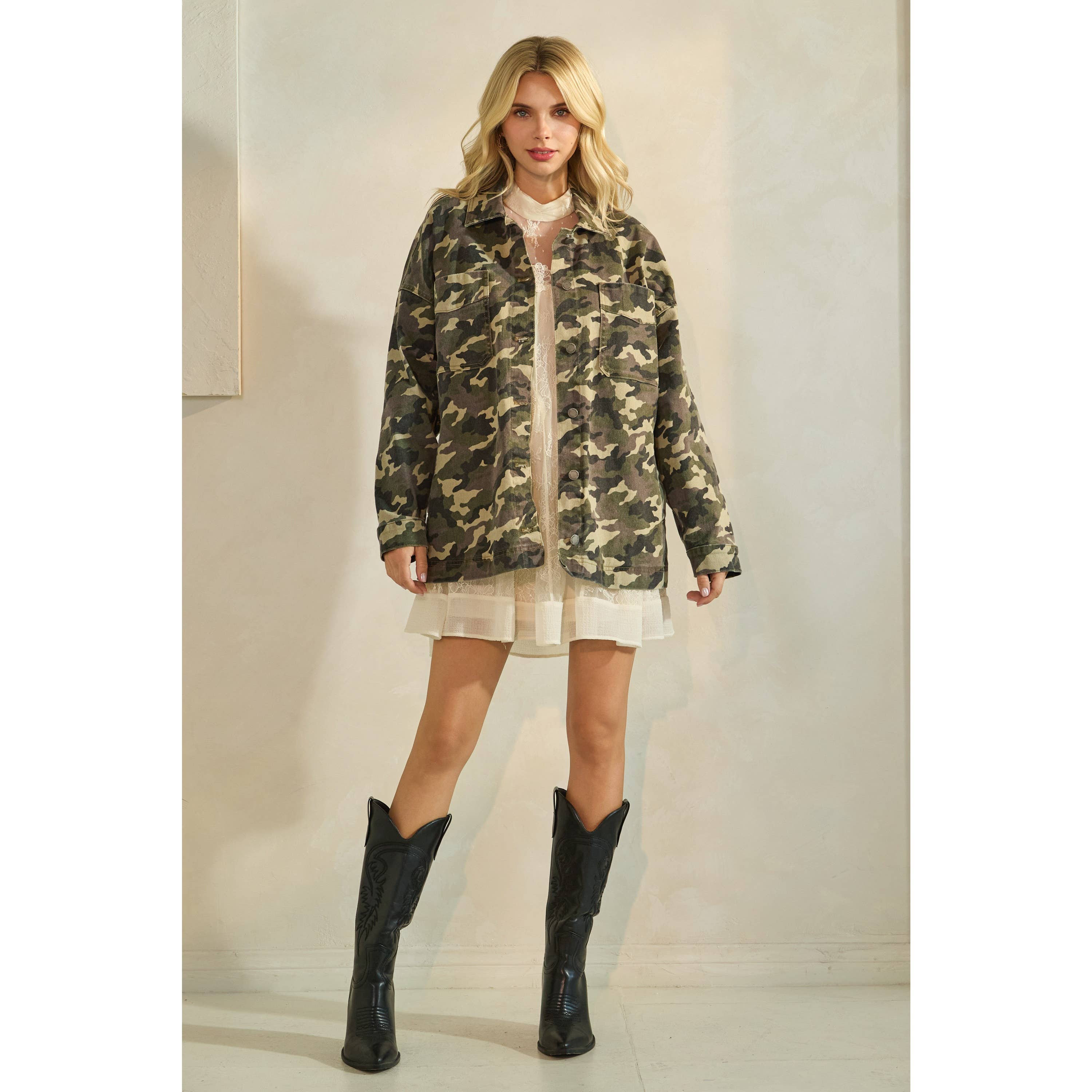 Oversized camouflage print jacket with front pockets and button closure, styled over a white tiered mini dress.