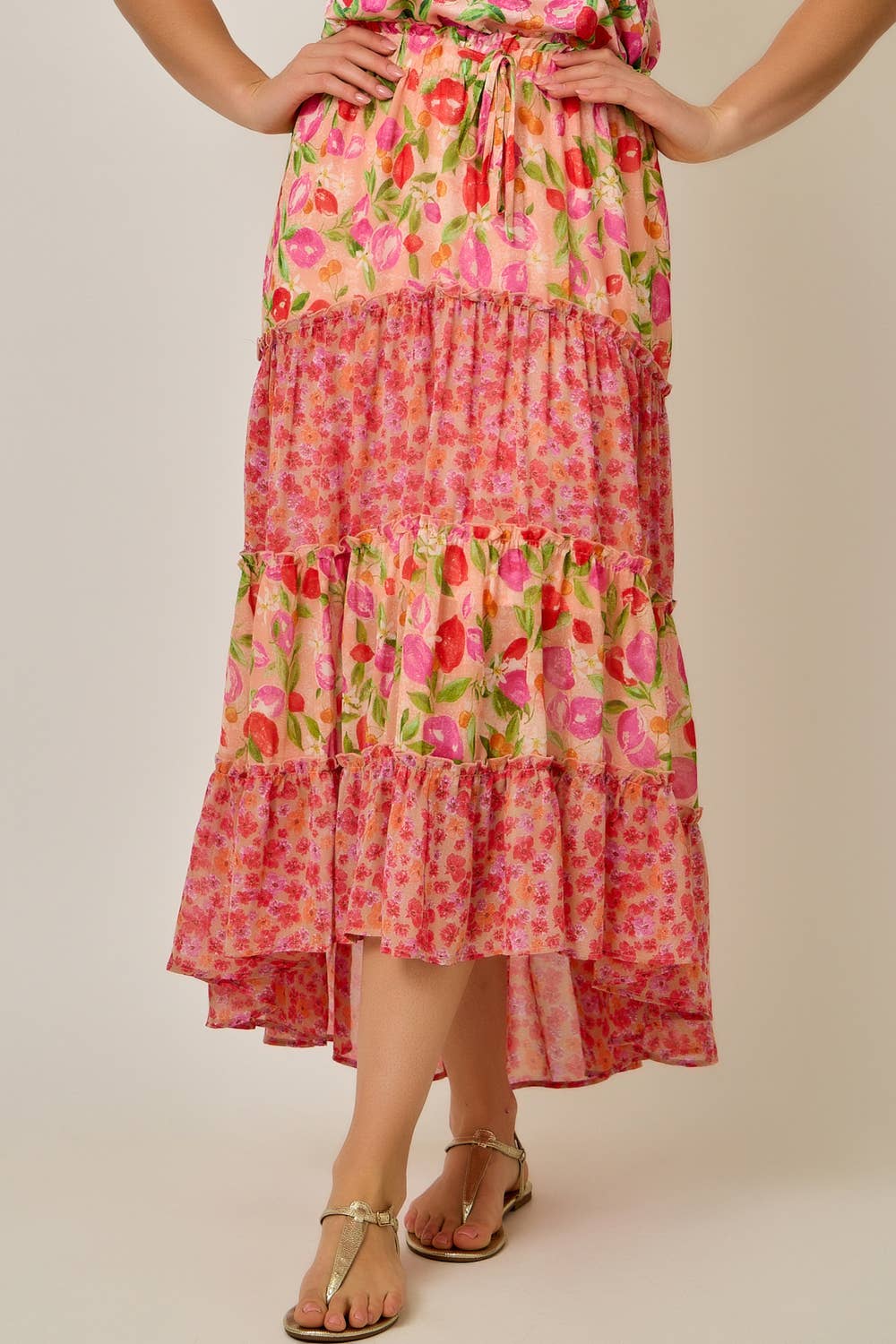 Woman wearing a floral tiered dress on a plain background