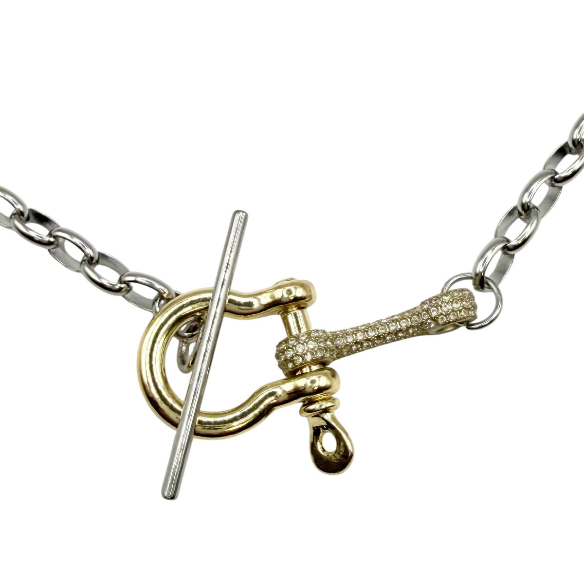 A close-up of a gold and silver toggle clasp necklace on a white background.