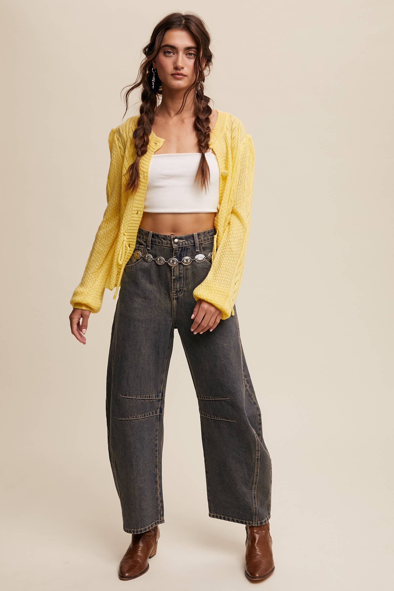 Dark wash wide-leg jeans with relaxed fit, seam detailing across the knees, and a high-rise waist, styled with brown ankle boots.
