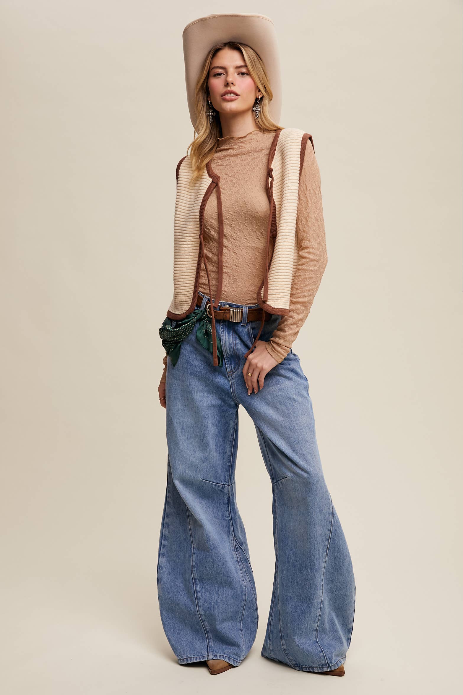 High-rise light-wash wide-leg jeans with front seam panels and knee darts, five-pocket style with zip fly, styled with tan long-sleeve top and pointed-toe boots.