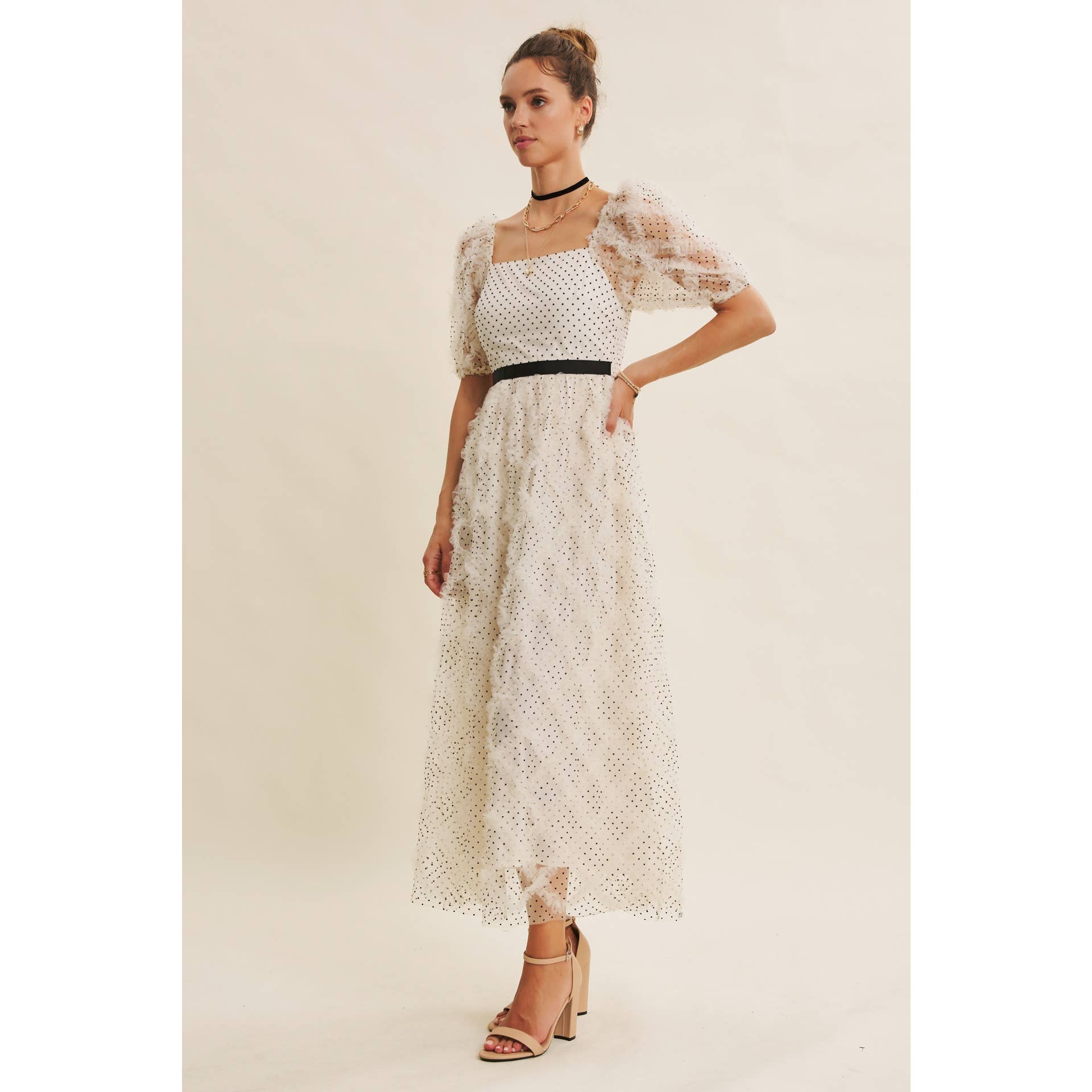 Three-quarter view — cream polka-dot tulle midi dress with puff sleeves, square neckline, black waist belt, side angle on model.