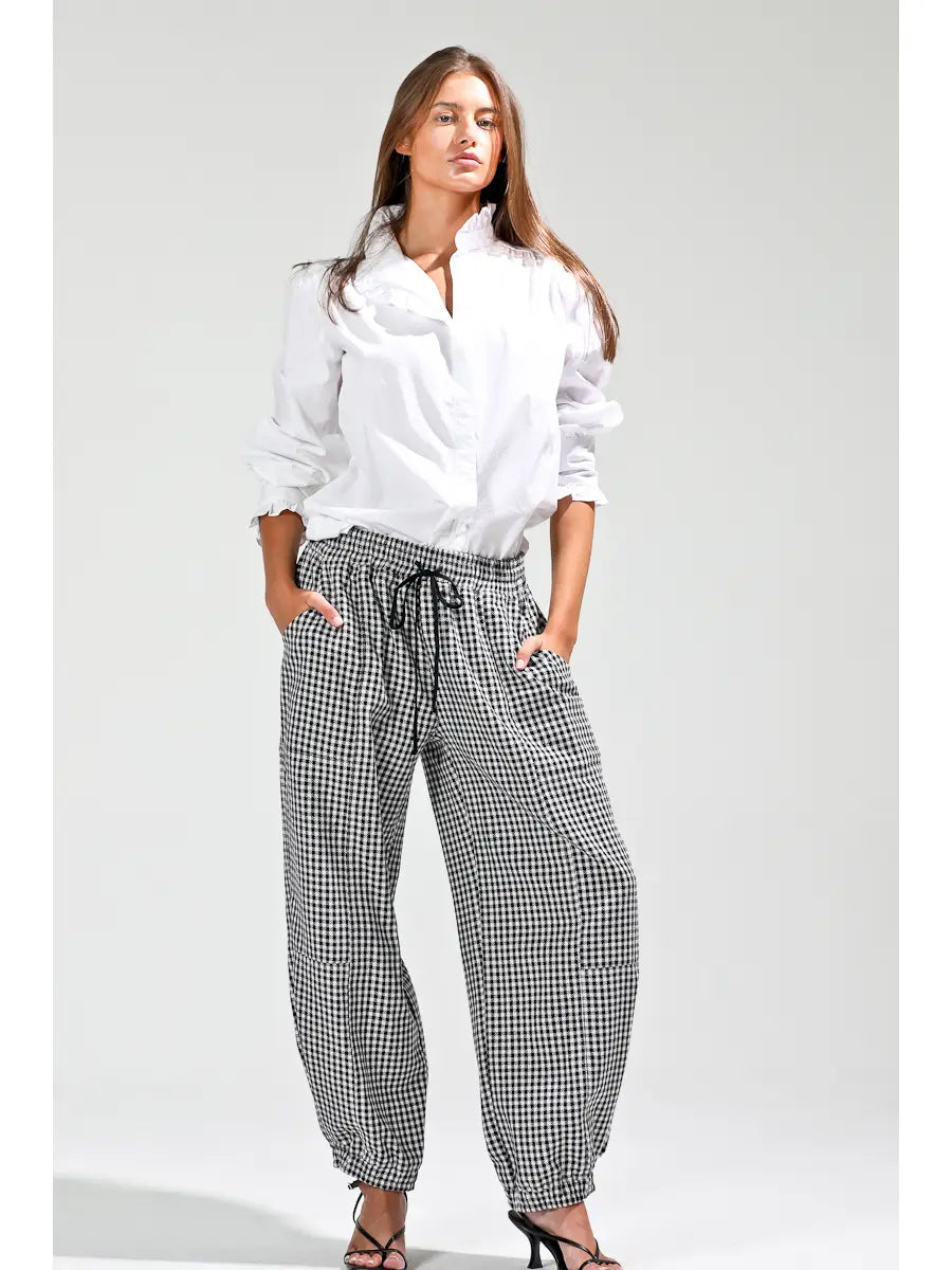 Model wearing NOABOA Mini Plaid Cuffed Barrel Pants styled with a white ruffled blouse and strappy heels, full-length front view