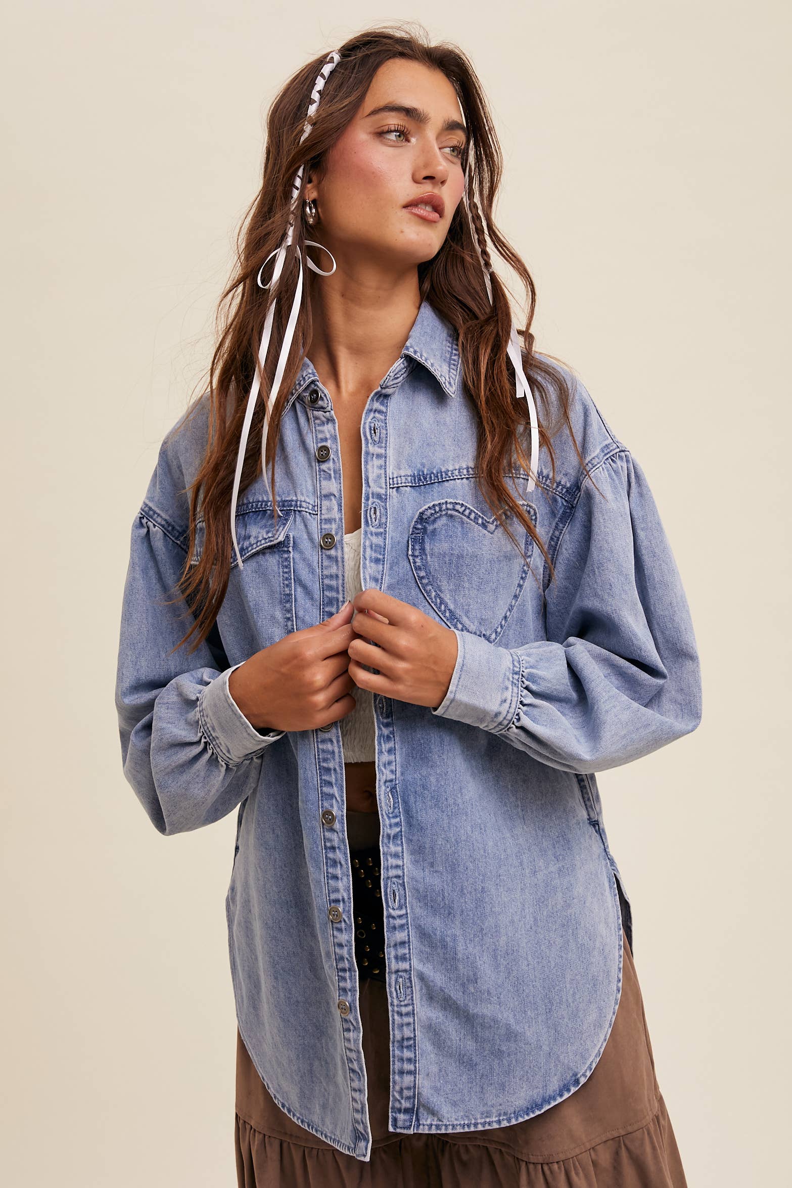 Light-wash oversized denim shacket with a heart-shaped chest pocket, button front, drop shoulders, balloon sleeves, and a curved hem.